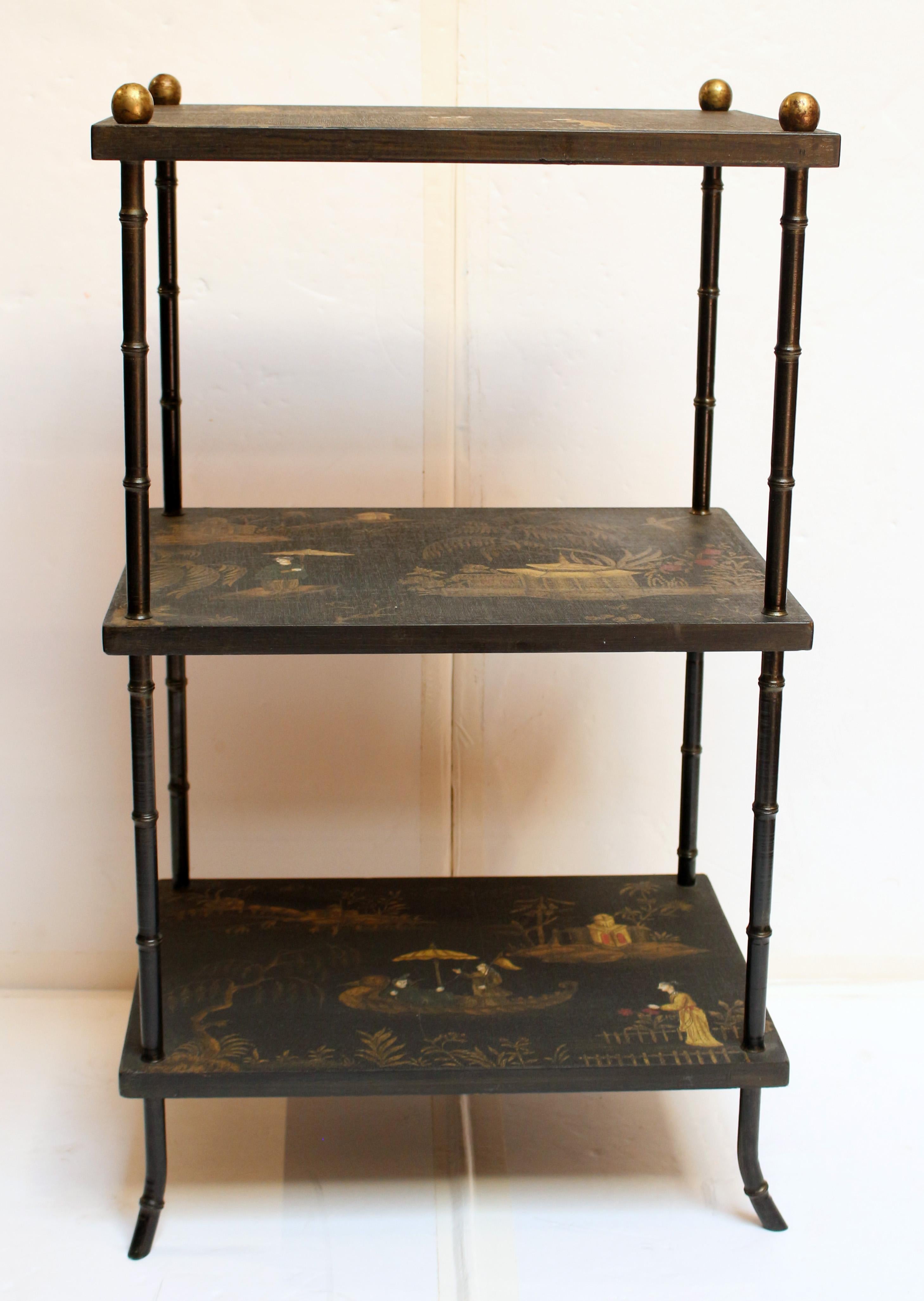 Circa 1920 Art Deco 3-tier side table. A very unique table, the surfaces of Chinoiserie decorated canvas wrapped wood. Faux bamboo painted metal uprights with gilt knob tops.
16
