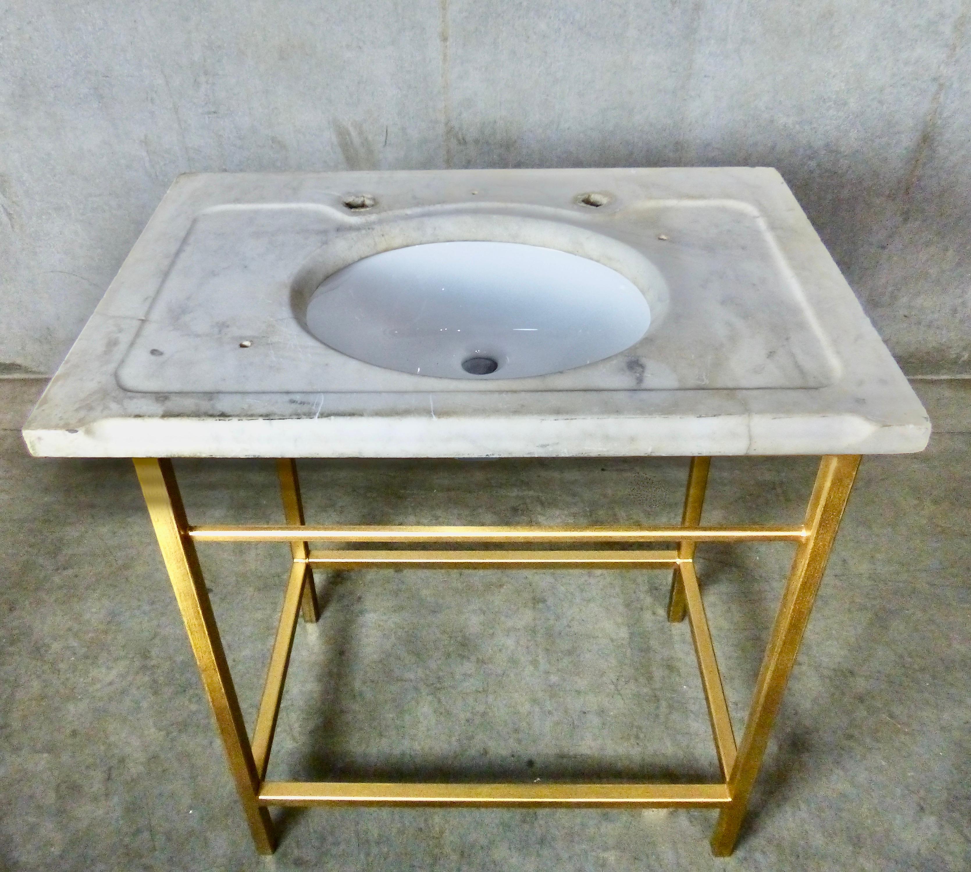This beautiful old marble vanity counter top has been outfitted with a bespoke steel frame — with brass finish — and a new porcelain sink. 
Great Hollywood Regency style!
Dimensions 34.5H” x 30W” x 20D”.