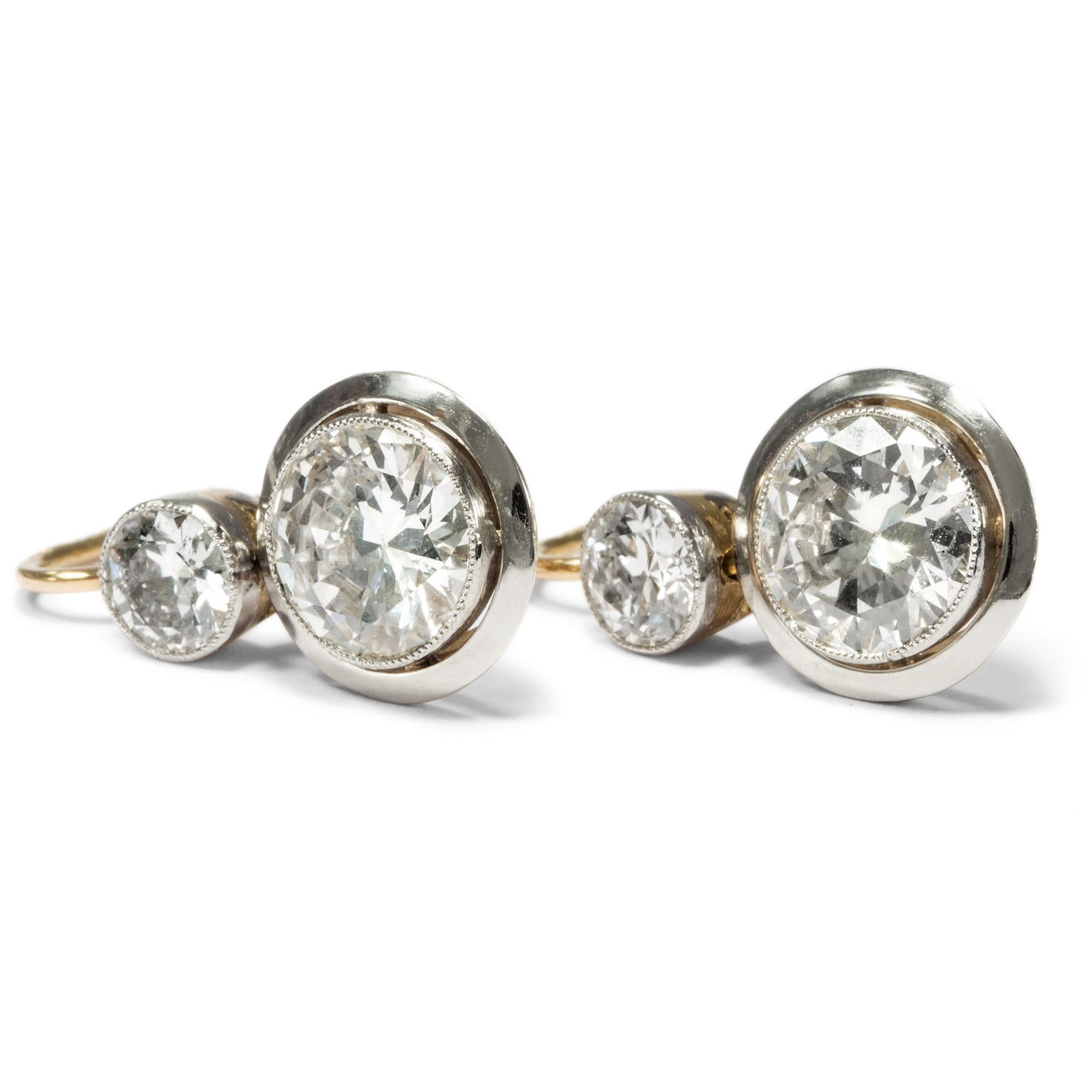 Four wonderful old European cut diamonds of overall 3,16 ct take centre stage in these precious earrings. The jewels take us an entire century back in time, to the years around 1920. Stylistically, they bridge the gap between the curvaceous Belle