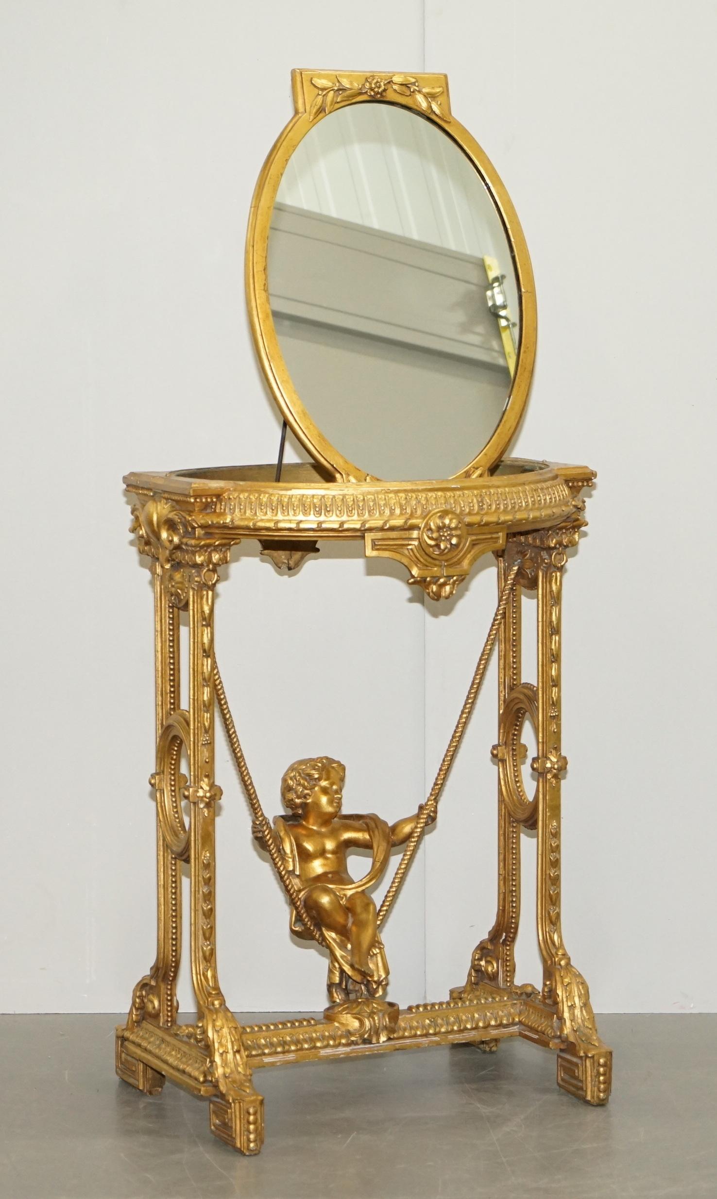 Nous sommes ravis d'offrir à la vente cette belle table d'appoint en bois doré et gesso des années 1920 avec un miroir sur le dessus et des putti sur la base de la balançoire

Une belle pièce, qui attire l'attention dans n'importe quel contexte,