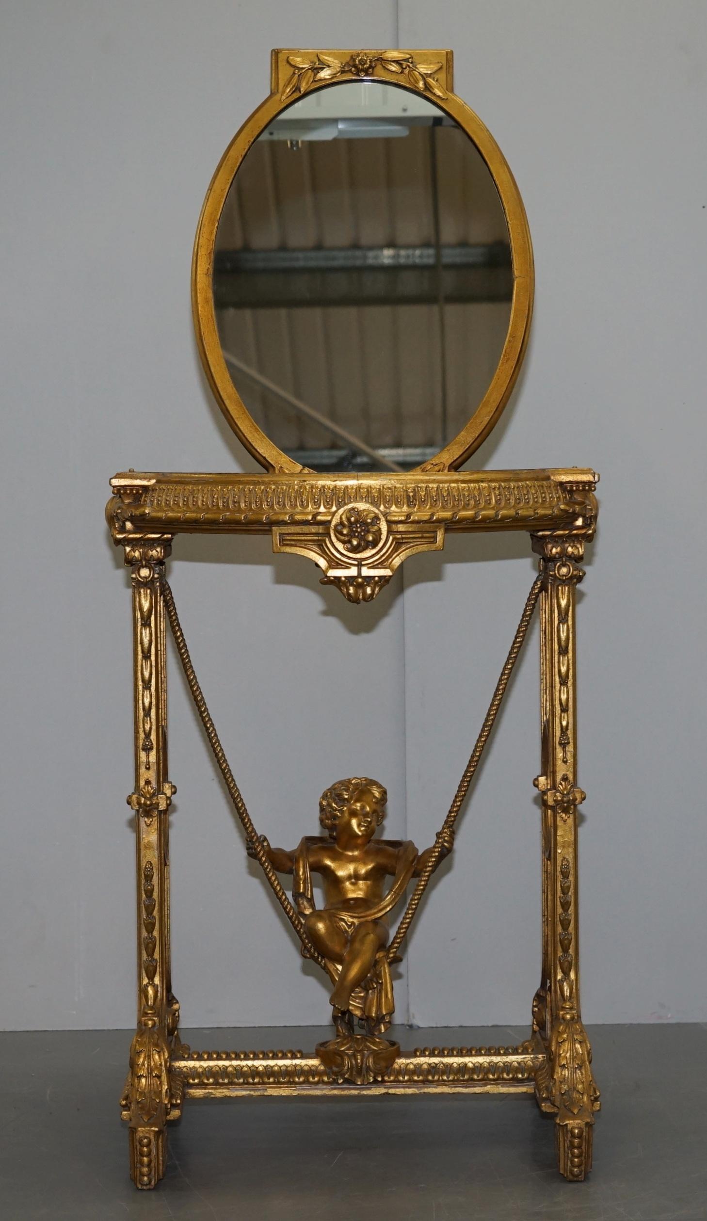 Art Deco Gold Giltwood Occasional Table with Mirror Top and Cherub Putti Swing circa 1920 For Sale