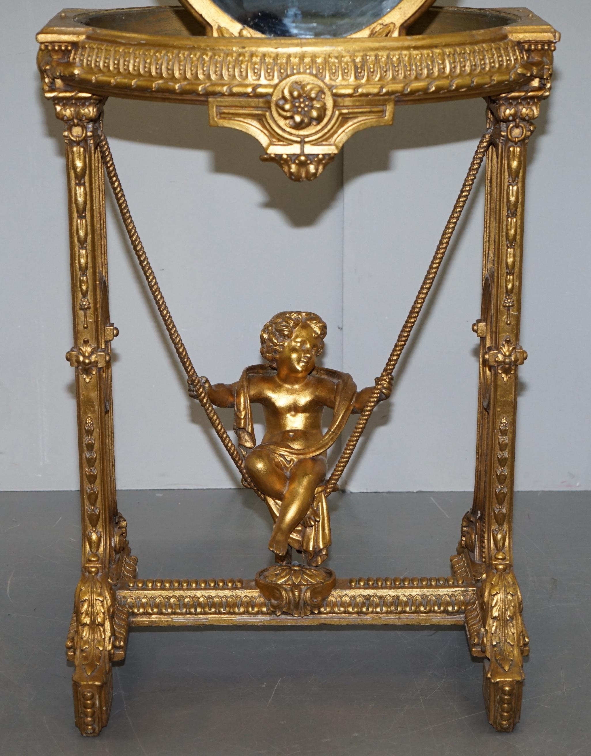 English Gold Giltwood Occasional Table with Mirror Top and Cherub Putti Swing circa 1920 For Sale