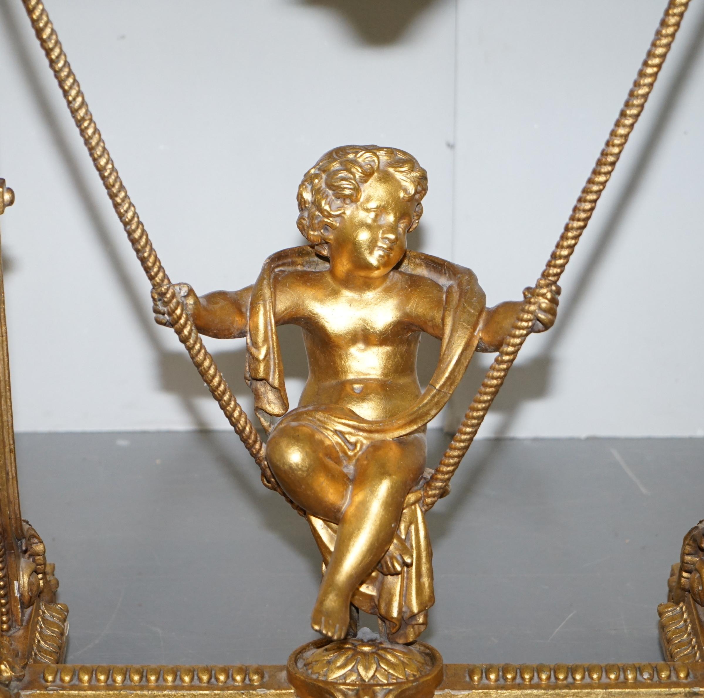 Hand-Crafted Gold Giltwood Occasional Table with Mirror Top and Cherub Putti Swing circa 1920 For Sale