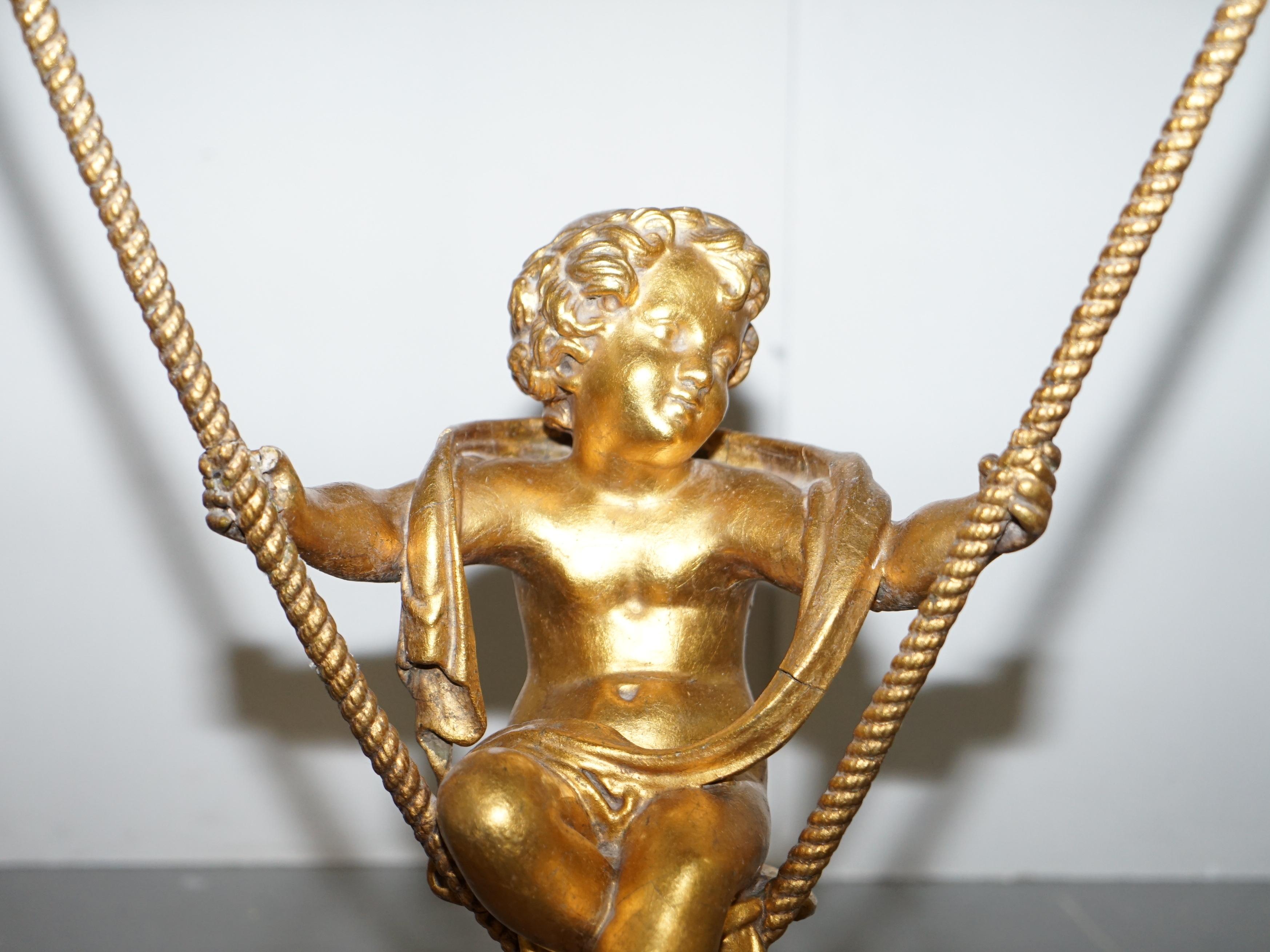 Early 20th Century Gold Giltwood Occasional Table with Mirror Top and Cherub Putti Swing circa 1920 For Sale