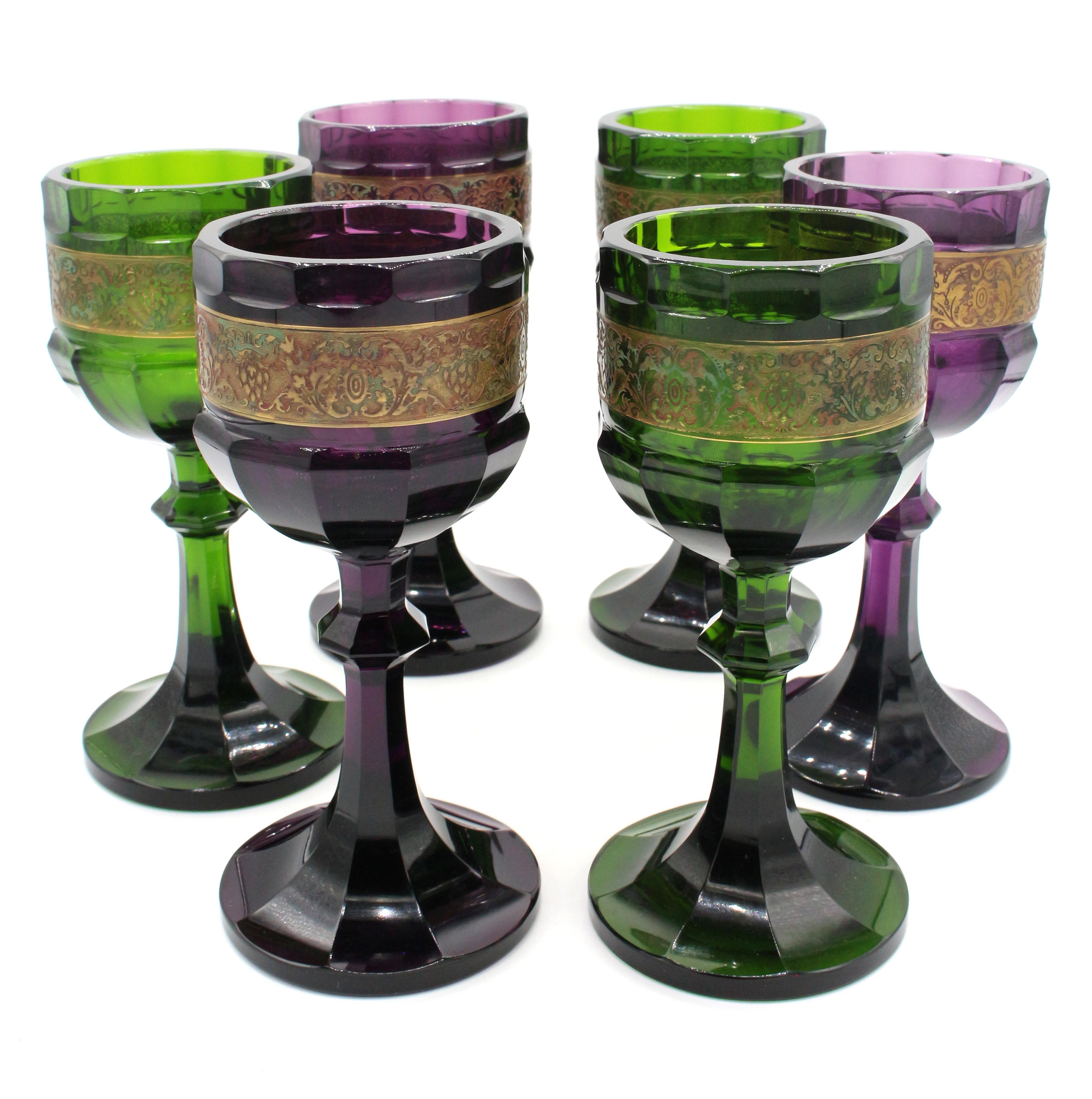 Set of 6 white wine goblets by Moser, Karlsbad, Bohemia, Arts & Crafts design, c.1920. Three of amethyst glass & 3 of emerald glass, each with intricate acid etched gilt bands of grape festoons, called 