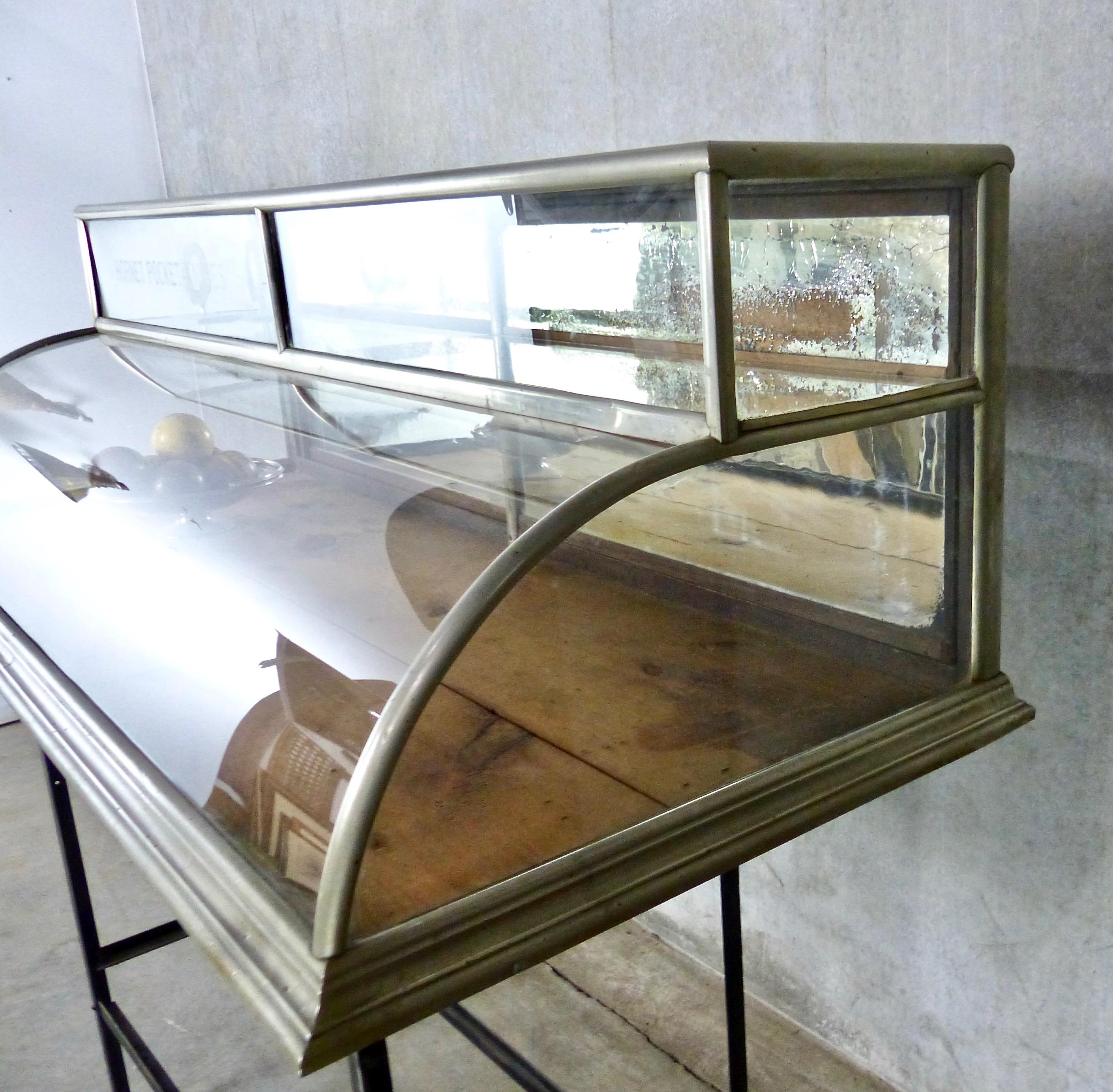 A rare and unusual curved-glass countertop display case that has an additional upper enclosed shelf. Originally made to display hornet pocket knives, it features mirrored sliding doors in the rear. Very rare form.
Made by A. Lange maker