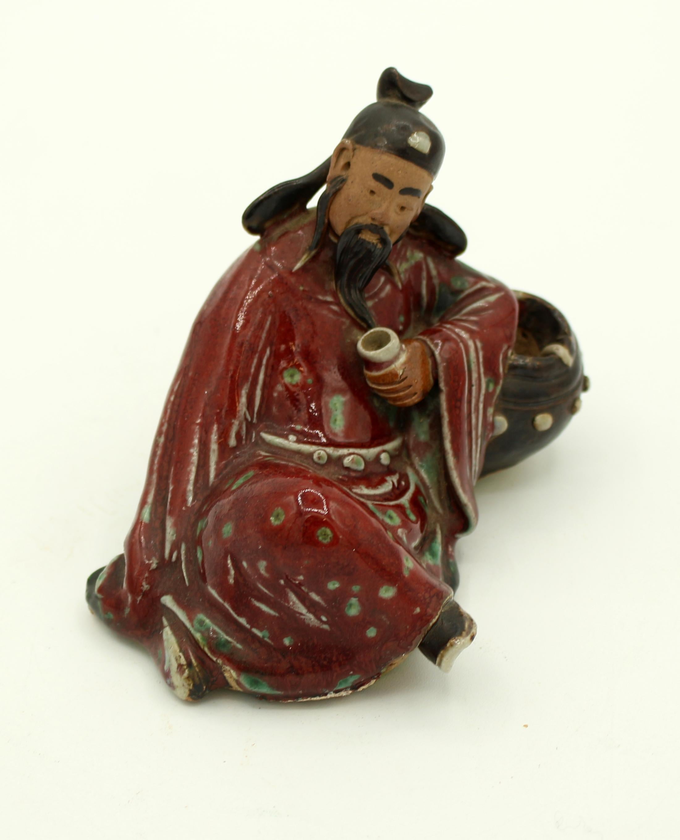 Circa 1920s-30s Shiwan pottery figure of the drunken Tai Pai. Richly glazed pottery. He is slumped on an empty wine cask holding an empty cup. Republic period. Measures: 4 3/4