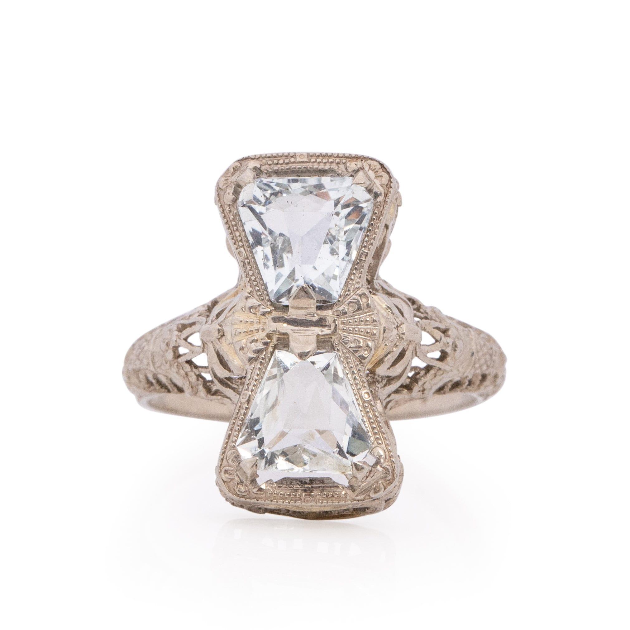 Presenting a genuinely distinctive piece, this Art Deco ring boasts exquisite details and a captivating bow motif. Meticulously crafted from lustrous 14K white gold, a vertical filigree-encased bow elegantly graces the finger, introducing a splash