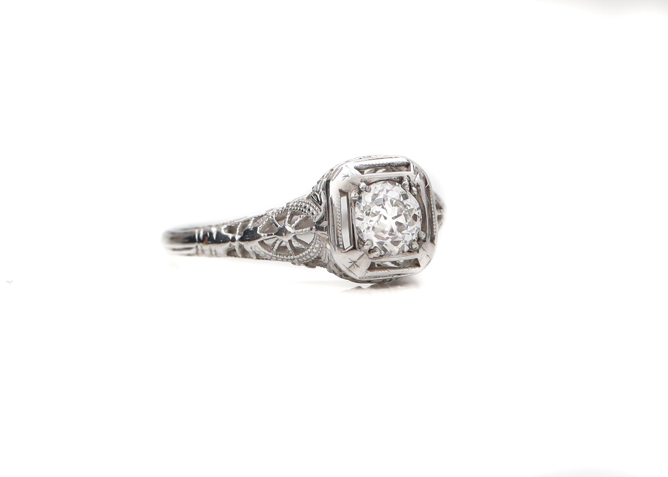 Here we have a beautiful 1920's Art Deco Engagement Ring featuring a .65ct old miner cut diamond as the center piece. Surrounding the diamond there is intricate design which is typical of that era. Lots of filigree pattern can be seen with a