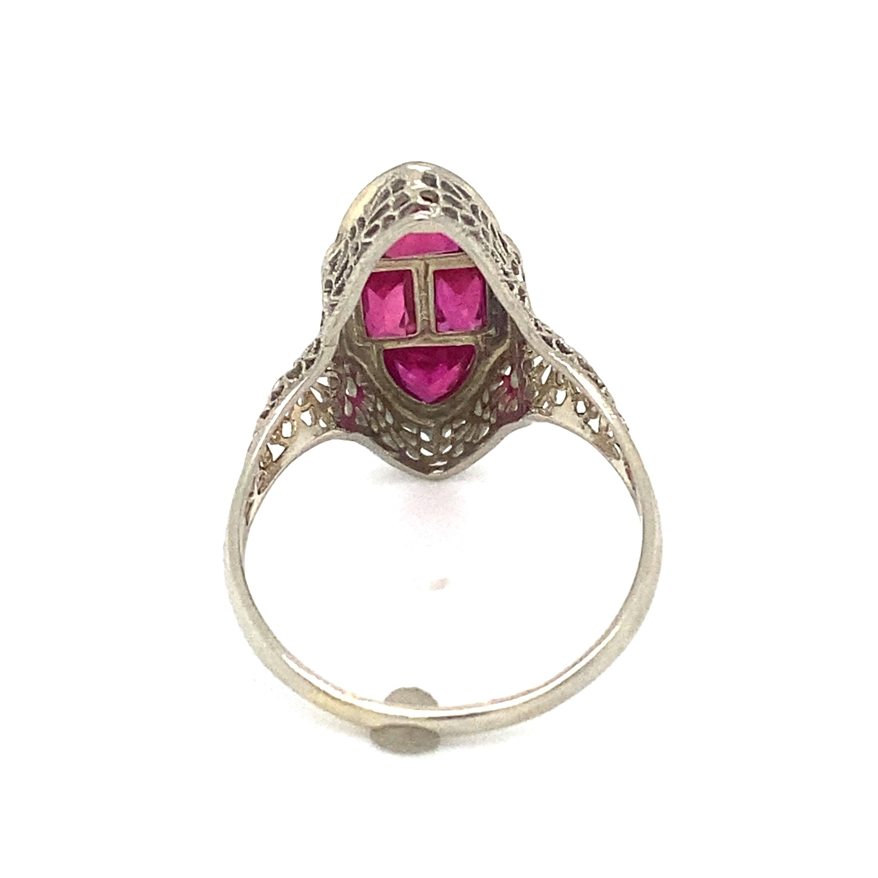 Item Details: This Art Deco ring features red glass ruby simulant in a geometric design.

Circa: 1920s
Metal Type: 14 Karat White Gold
Weight: 3.5 grams
Size: US 9.25, resizable