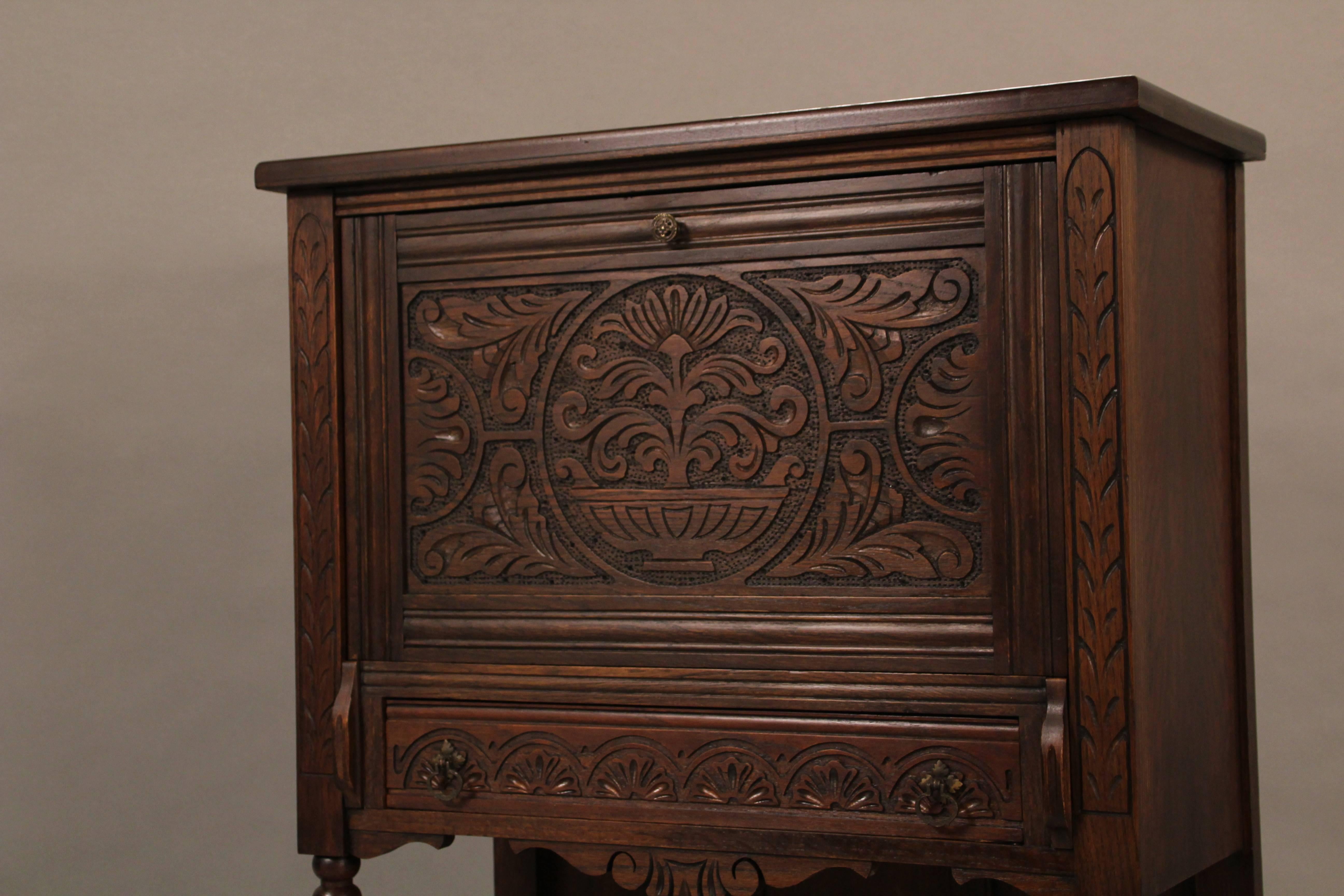 1920s carved vargueno type desk with drop from panel that converts into a writing desk.