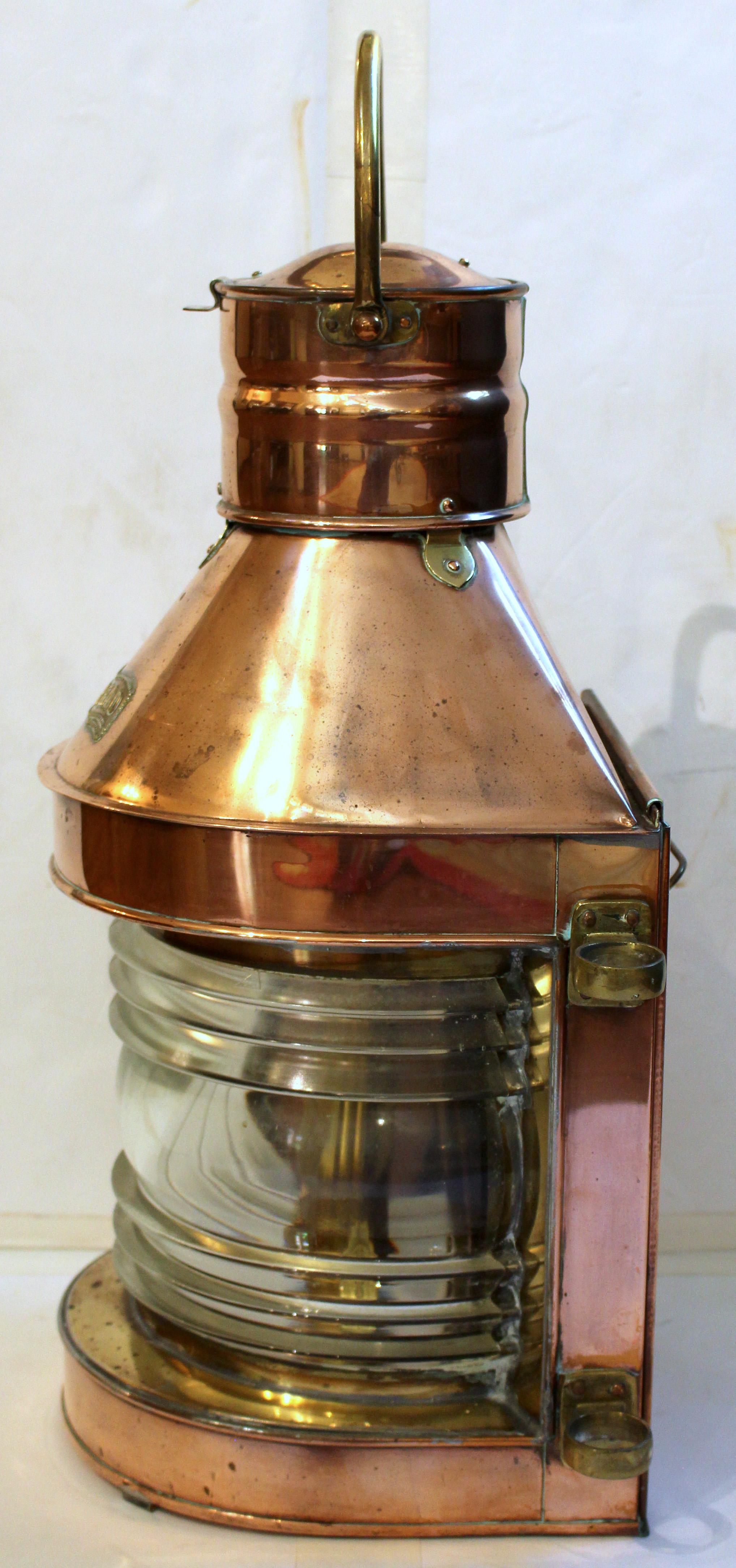 Circa 1920s ship's masthead lantern, English. A fine example of copper with brass fittings & heavy molded clear glass panel. Retains the likely original oil lmap on copper sliding panel, marked 