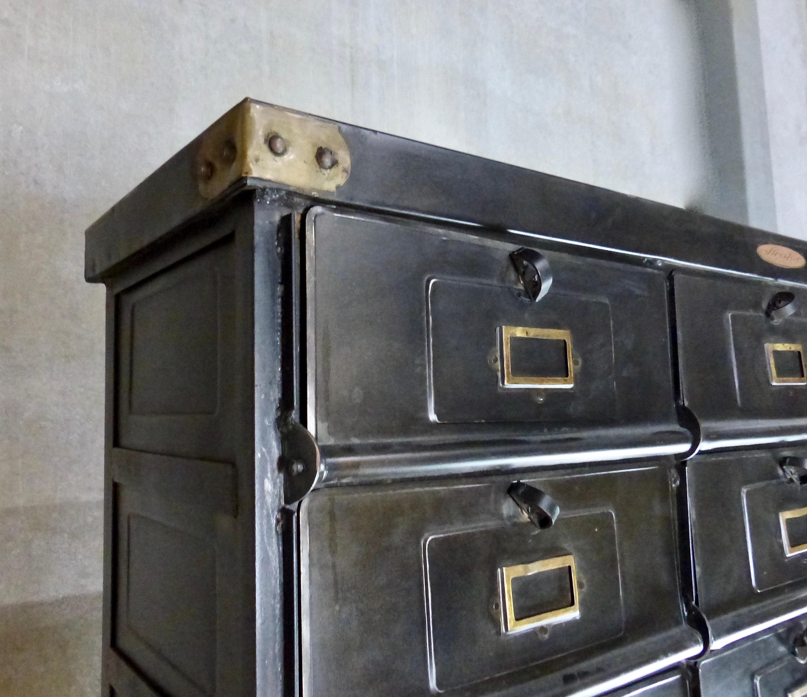 Blackened steel apothecary-style cabinet with 30 individual drawers, made in France by Strafor, Forge de Strasbourg. The substantial, circa 1920 cabinet is beautifully forged with intriguing details, including brass accents on the drawer fronts as