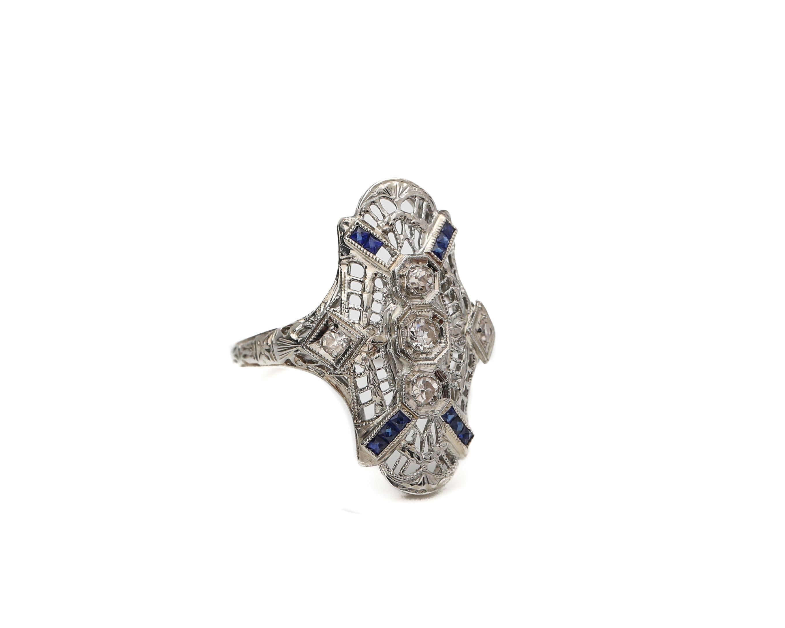 Description: 
Here we have a lovely example of an Art Deco Shield Ring. This beauty has a beautiful filigree design accented with diamonds and sapphires. This classic beauty would make a lovely addition to any vintage lover's collection!

This is a