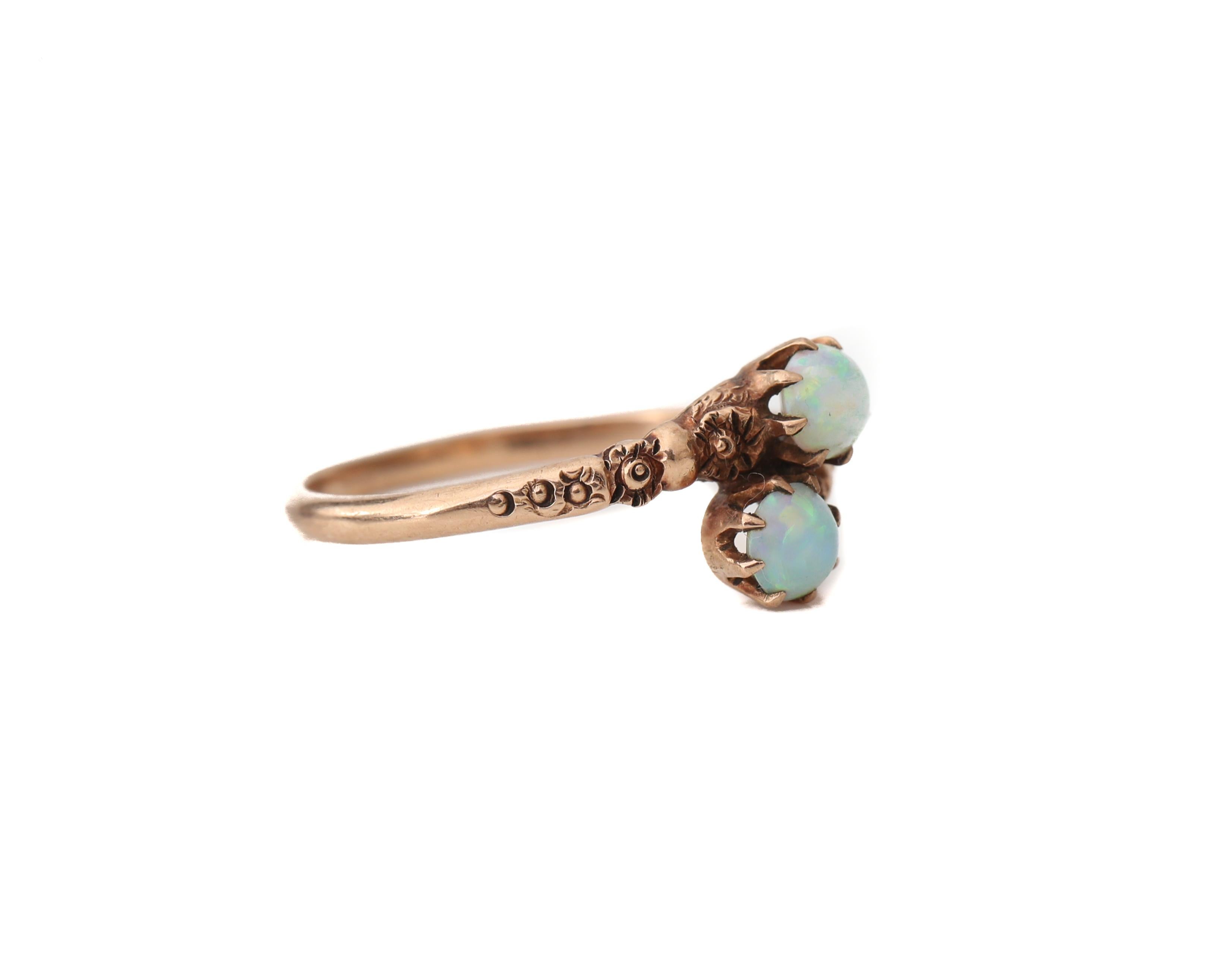 This Vintage beauty is a perfect example of an antique carved ring, hand-carved by a master jeweler in the 1920's. The two radiant opals steal the show! Intense flashes of green over a humble greyish sky blue are magical! 

This is a true antique