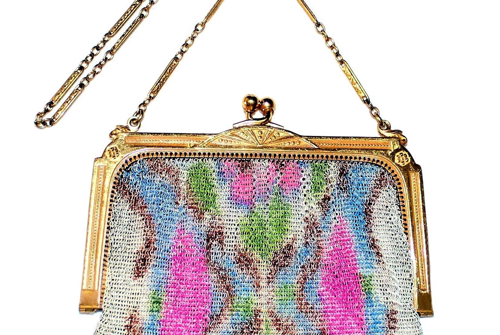 Circa 1920s to 1930s Whiting & Davis delicate gold tone metal mesh purse embellished with a bright floral motif, hanging from a bright gold tone metal frame.  Inside is a pale-peach satin lining that has a gathered side pocket with a small, round