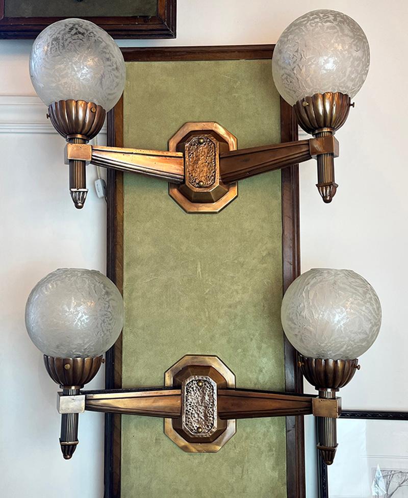 Stunning and rare pair of cast bronze Art Deco double light sconces. Bronze castings are beautifully done and have a softness and quality to them not found today. These would have been commercial grade reserved for offices, schools , banks and