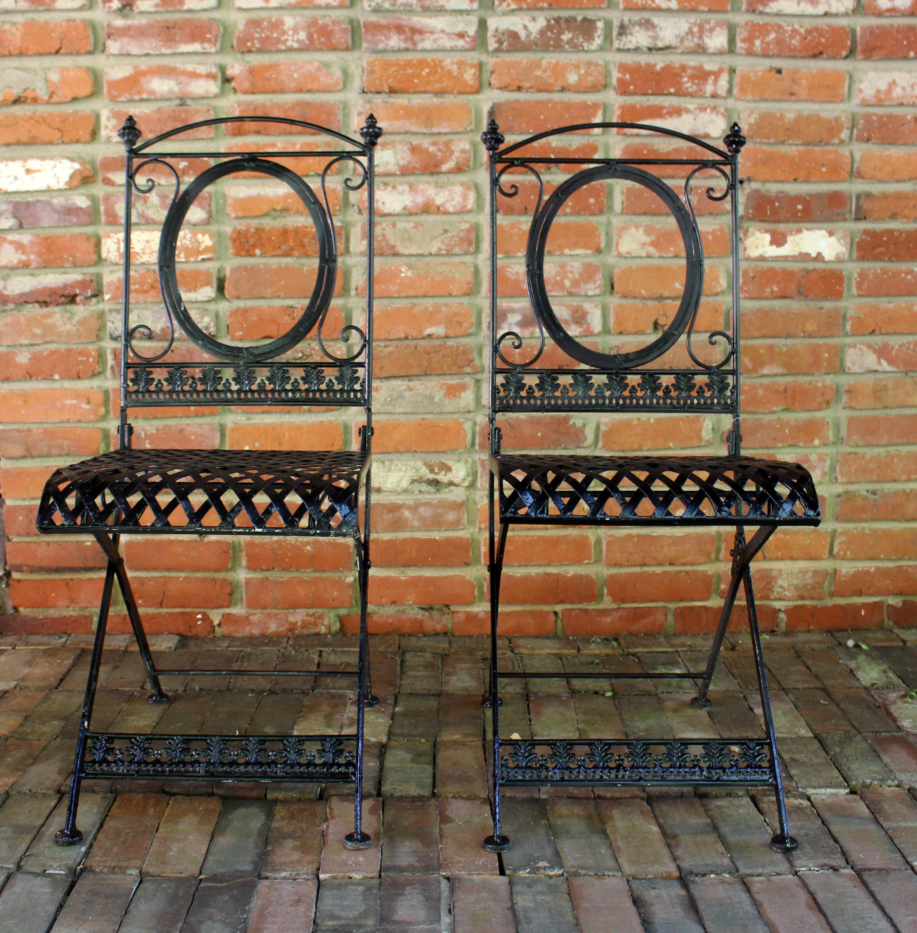 Circa 1930-50 French wrought iron garden table & pair of chairs bistro set. Latticework table top & seats with acanthus leaf & rope aprons, chair back panels & stretchers on all pieces. Open oval medallion backs. Newly repainted.

