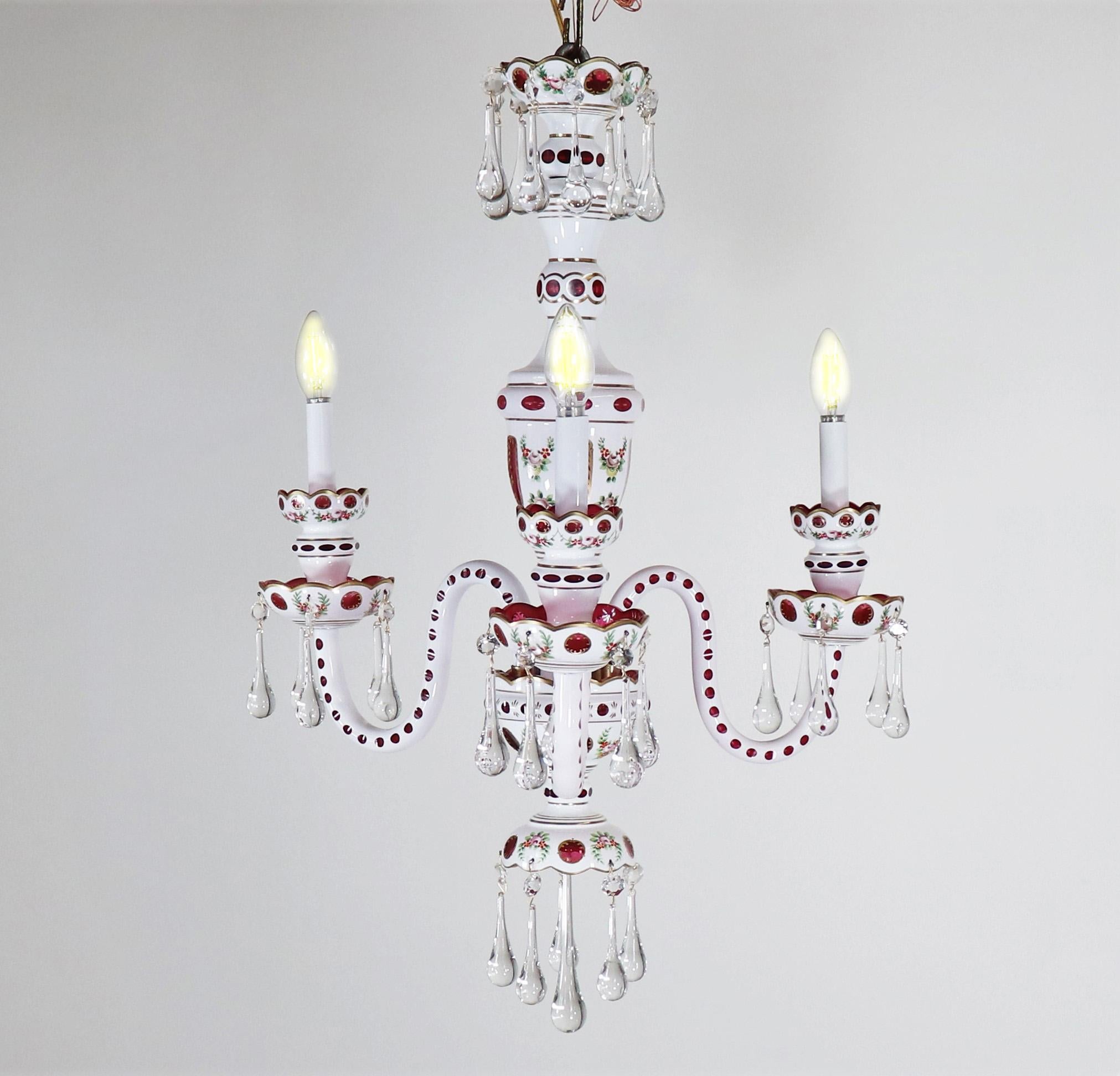 Questo splendido lampadario in vetro di finta porcellana cecoslovacco è stato creato nello stile della Moser Glass Company. Ha tre bracci ondulati con coppe a due livelli con bordo smerlato. Il corpo di questo pezzo è realizzato in vetro color