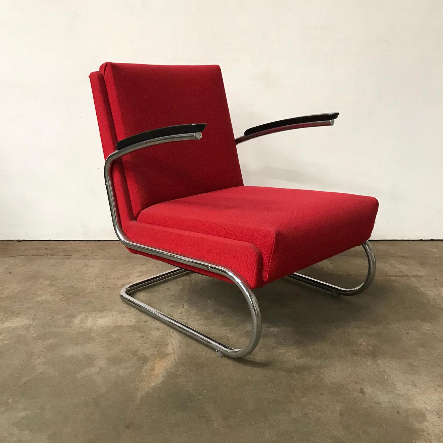 Tubular easy chair in burgundy red and black armrests. This beautiful easy chair is out of one tube. The upholstery is in a burgundy raspberry red and in good condition although it shows some traces of wear like in the top right and left corner on