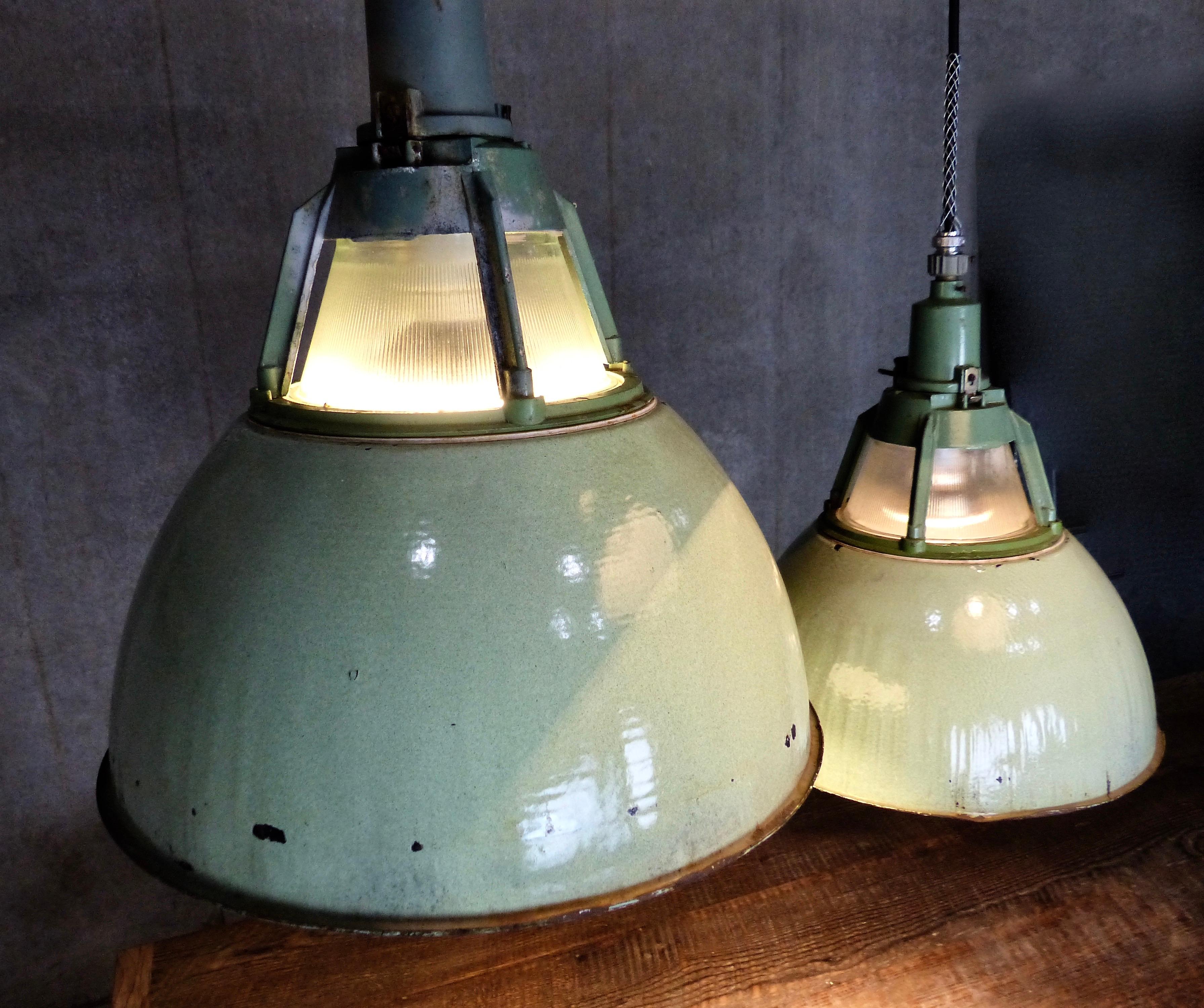 Set of six European industrial pendants in original pale green enamel. Rippled glass shade (within a cage) plus protective glass shade cover. Great look in a rarely seen light. Re-wired, and inspected and approved to current electrical standards;