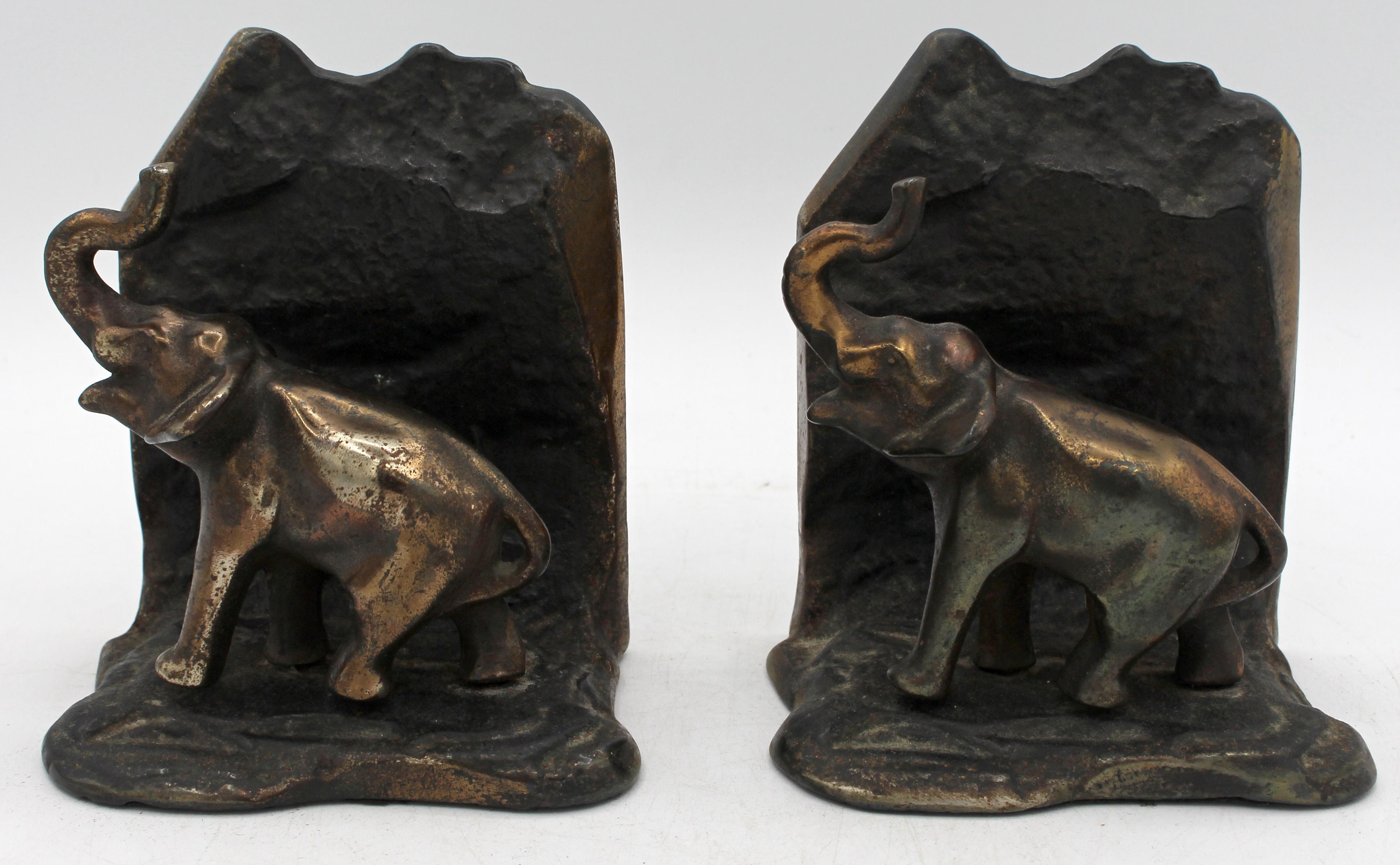 Coppia di reggilibri a forma di elefante del 1930 circa, inglese. Ghisa bronzata. Design fluido in stile Art Déco. Incantevoli elefanti che camminano, con le proboscidi in aria. 4,5