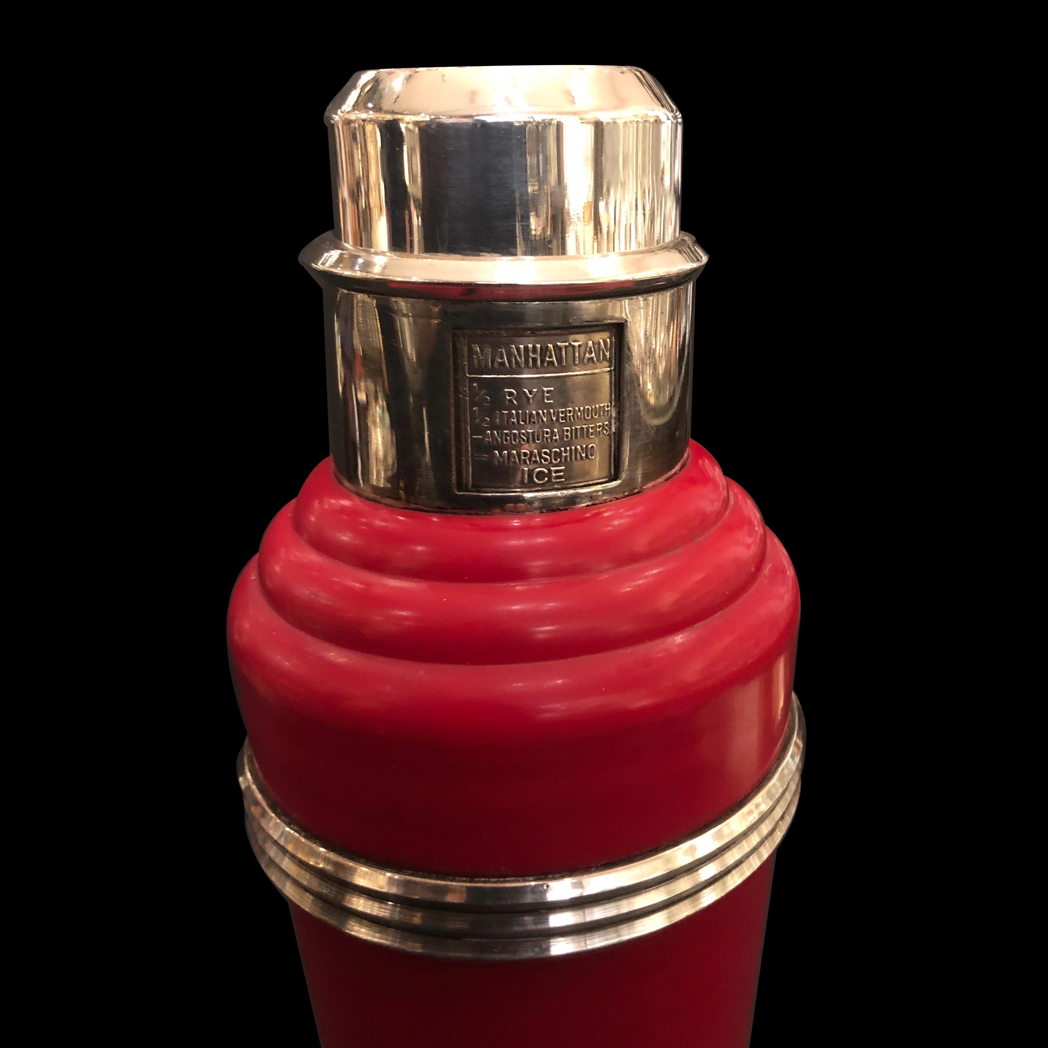 In one- tone red, 1 quart capacity with strainer, with 1 gill chromed integral measuring cap and with 'non-spill' spout, the collar rotating to reveal recipes for the famous 8 different cocktails.