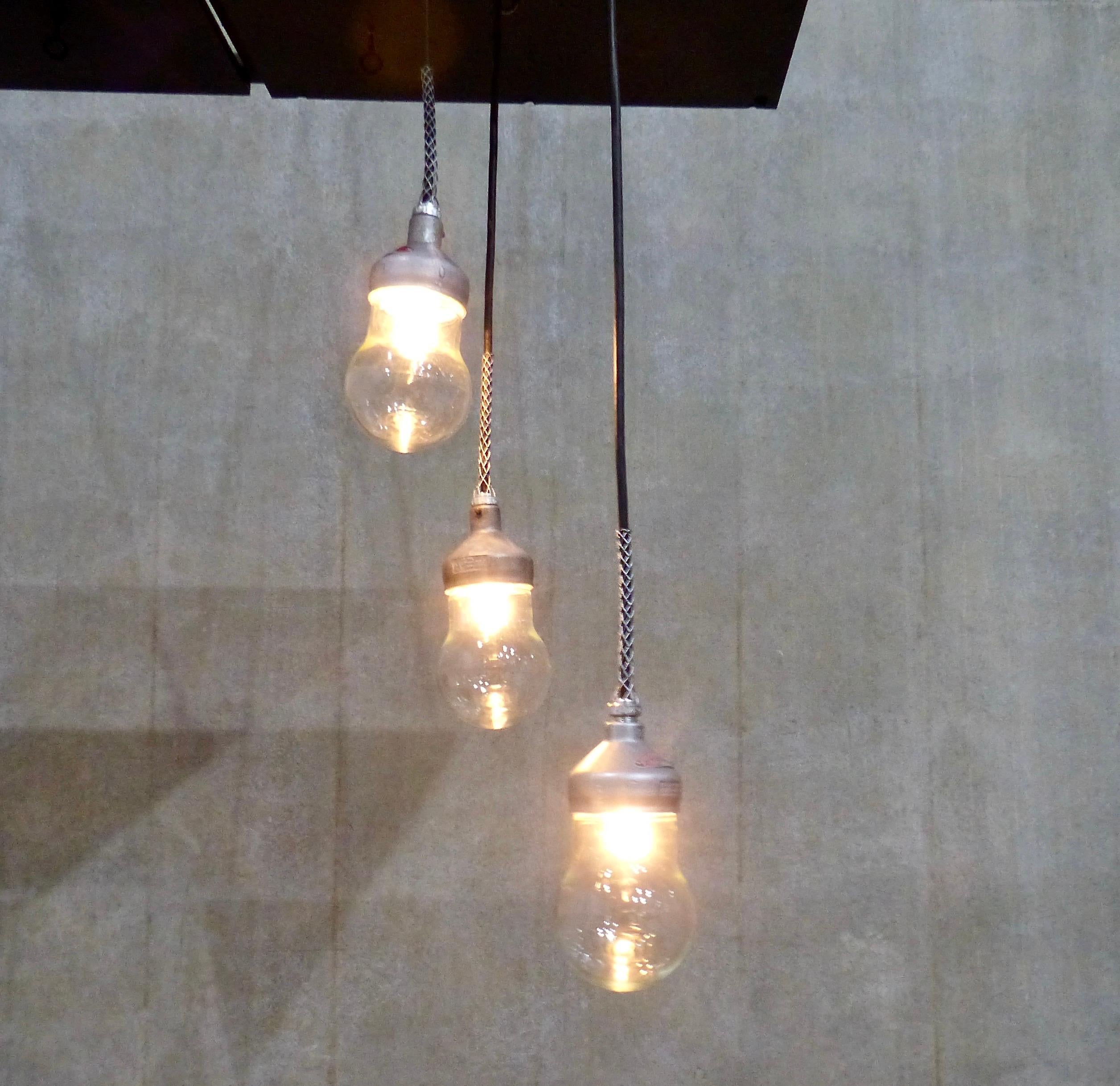 The rare, smallest version of Crouse Hinds Industrial pendants. These circa 1930 lights are made with cast metal tops and feature teardrop glass shades. Inspected and approved to current electrical standards; ceiling mounting plate included. Height