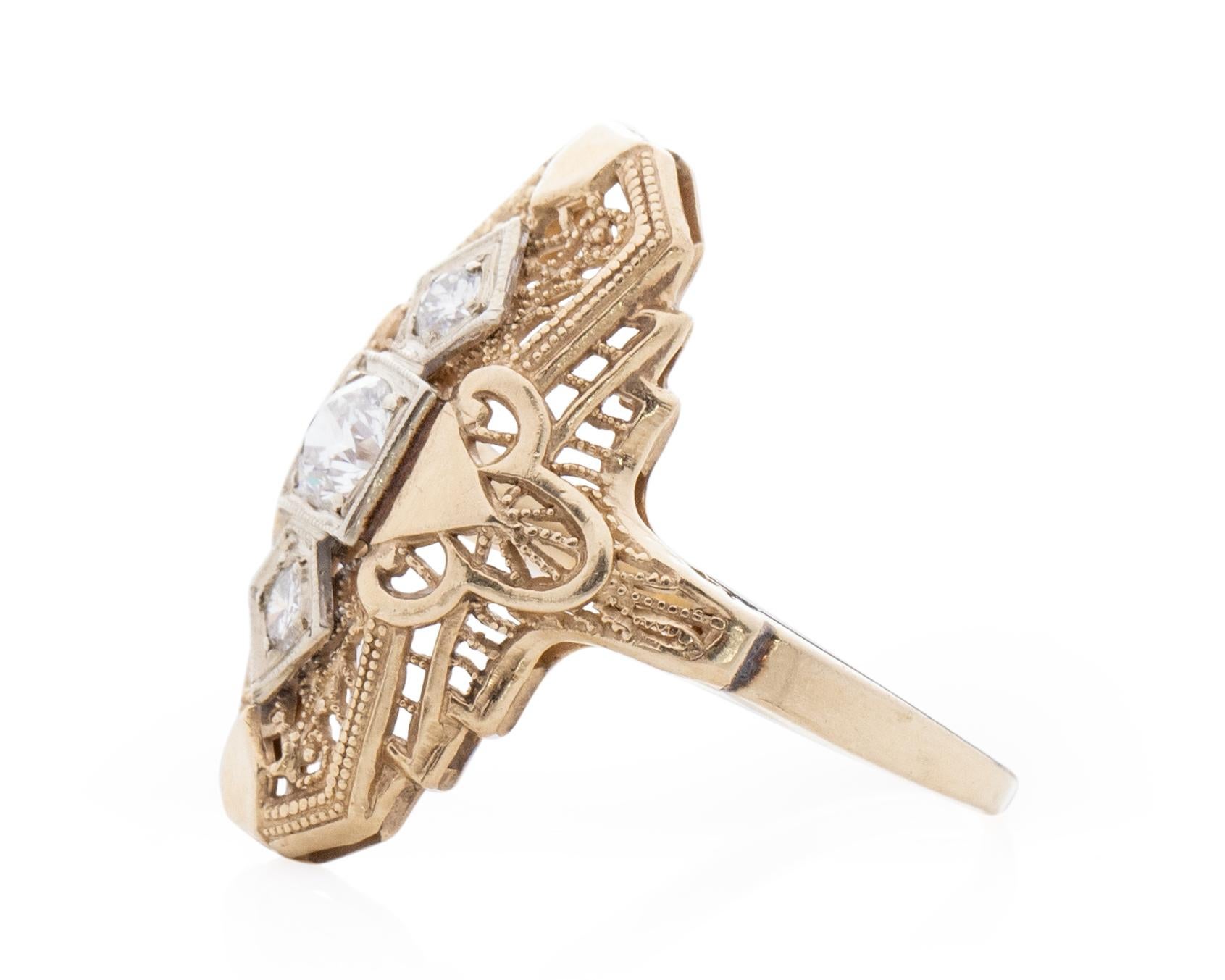 This lovely example of an Art Deco shield ring is crafted of 14K yellow gold. Intricate filigree designs surround 3 sparkling diamonds on this vintage beauty. This is a true vintage piece and would make a great addition to any vintage lovers