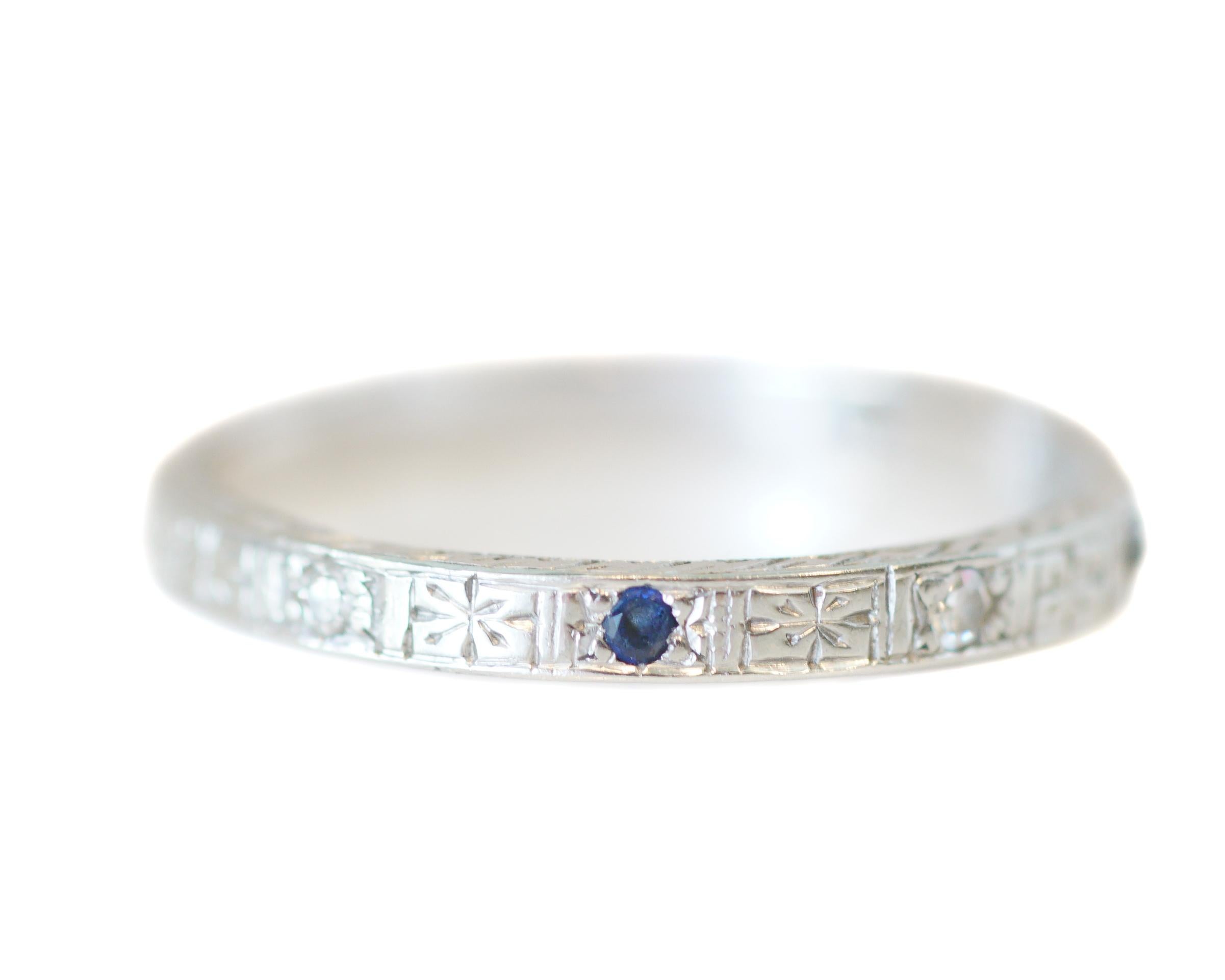Description: 
This piece is a 1930s Art Deco style 18K white gold wedding band with alternating diamonds and blue sapphires. The gems are spaced evenly around the beautifully engraved band.  A perfect band with a just enough pop of color that will