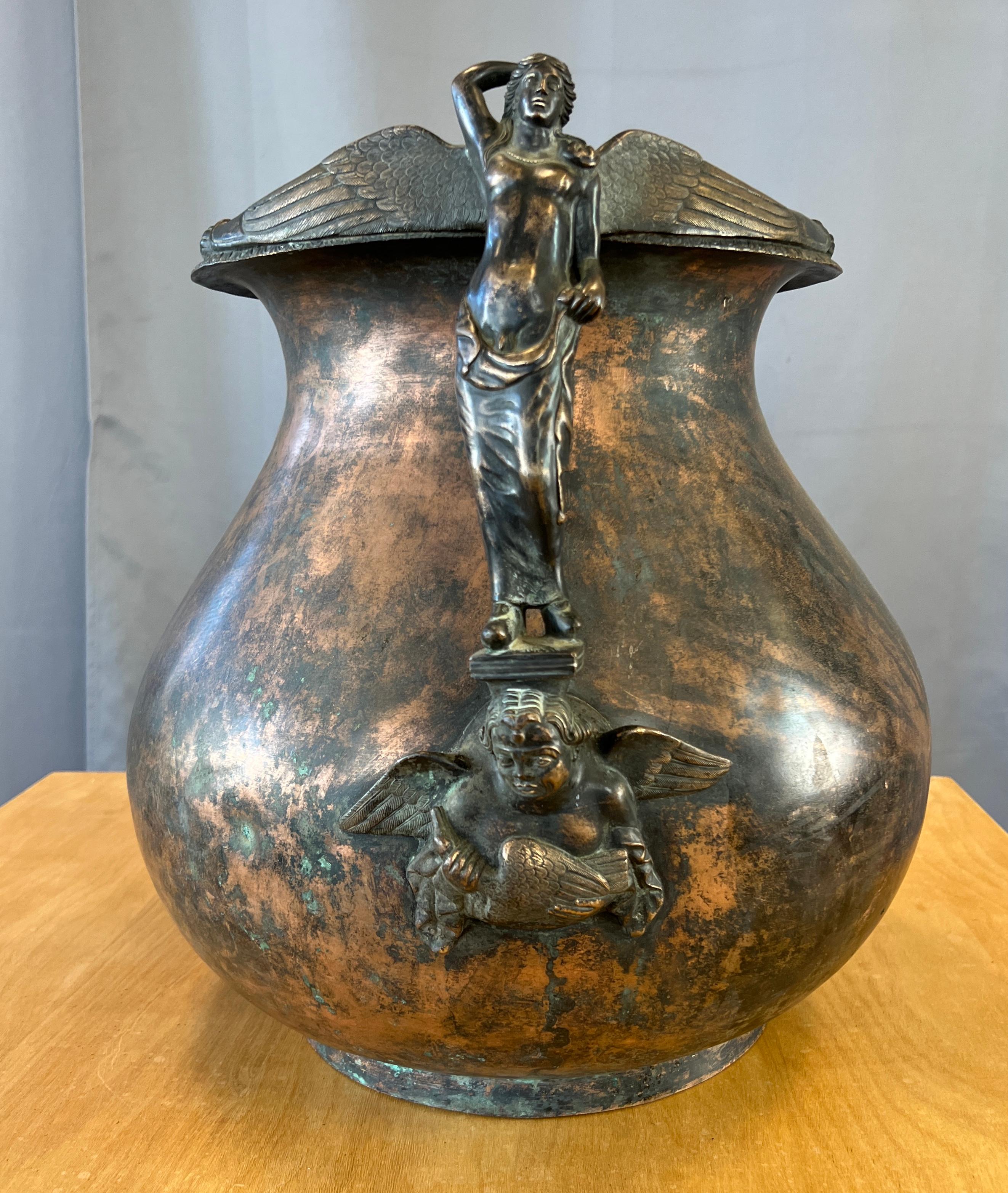 Offered here is a wonderful bronze jardinere or urn. 
Has a sculptural hermaphrodite handle, that starts with a cherub holding a goose, then with the hermaphrodite standing on a platform atop the cherub. With it's wings stretched across the lip of