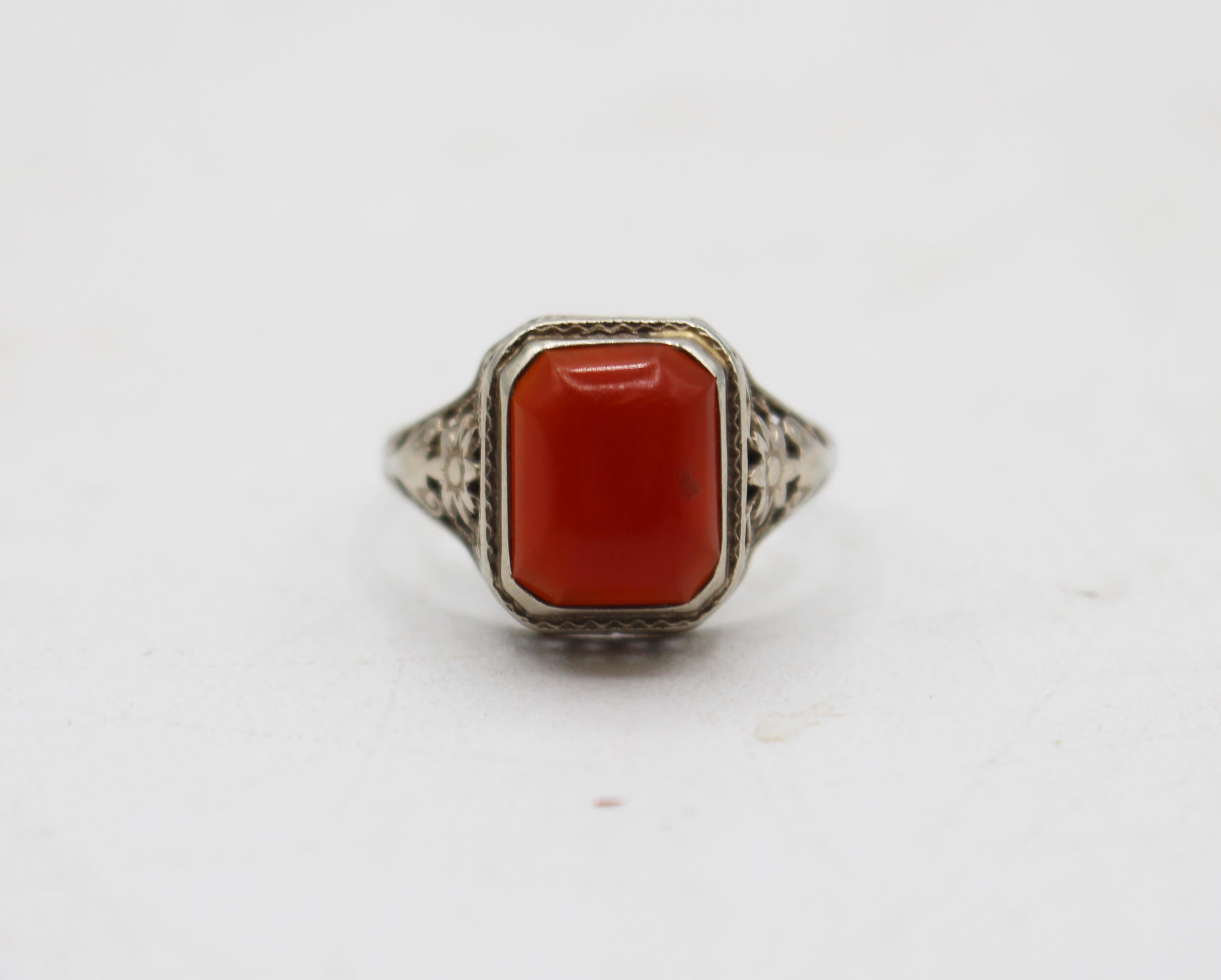 Anello in filigrana di corniola e oro bianco 14k degli anni '30 circa. Artigianato di pregio. Taglia 6.5. La filigrana a reticolo è accentuata da fiocchi Art Deco.
1