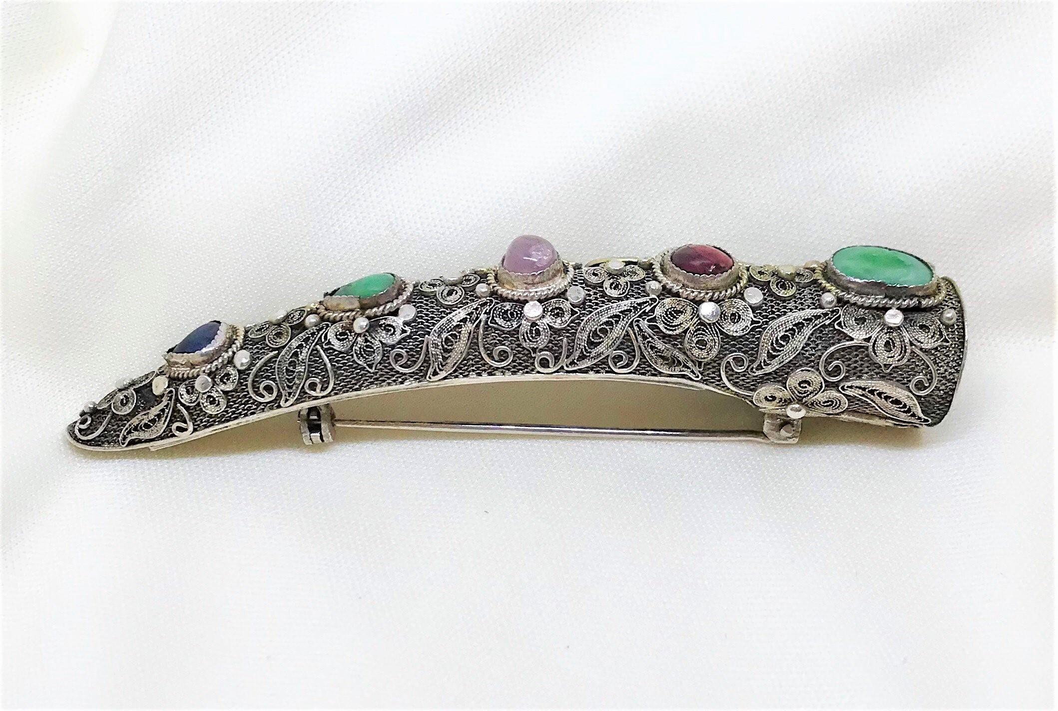 Circa 1930s to 1940s Chinese sterling silver nail cover brooch embellished with ornate floral filigree designs and bezel set with jade, amethyst and lapis stones.  It measures 3.25