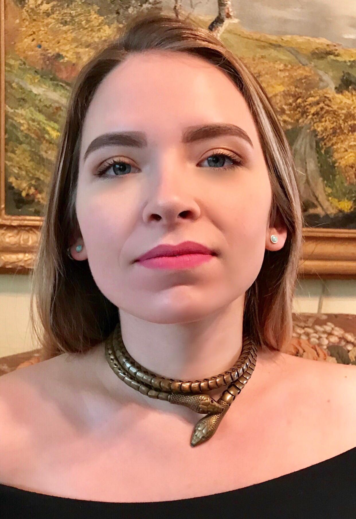 Circa 1930s Egyptian Revival, articulated brass snake figural necklace.  The piece is flexible and has a slight stretch to it allowing it to adjust in size.  It fastens at the snake heads and can also be worn as a belt.  The eyes have been set with