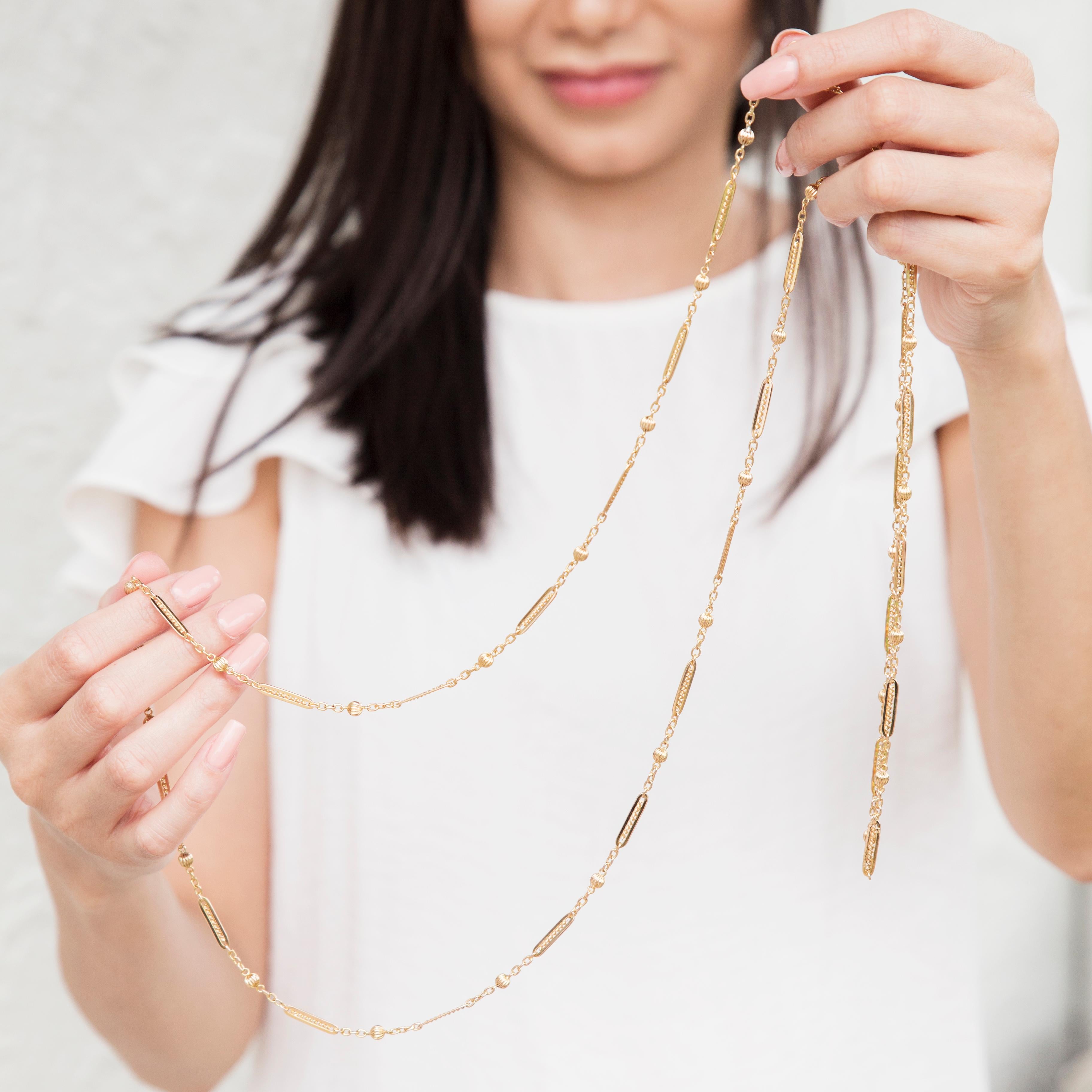 Forged in 15 carat yellow gold, Circa 1930s, this nostalgic vintage muff chain is an alternating series of modified paper clip link and fluted balls. This classic necklace is named The Millie Necklace. Her length lends herself to a plethora of
