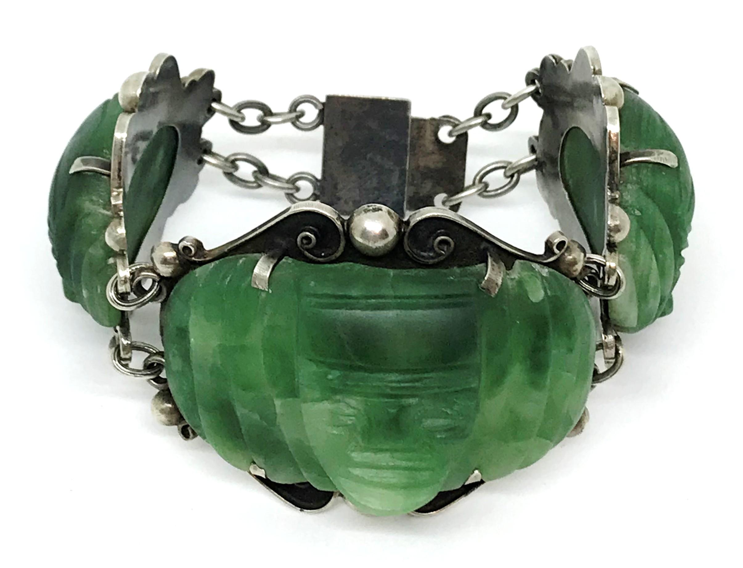 Circa 1930s to 1940s artisan made, sterling silver large link bracelet.  It is prong set with hand carved, green onyx masks and embellished with sterling silver motifs.  The bracelet measures 7