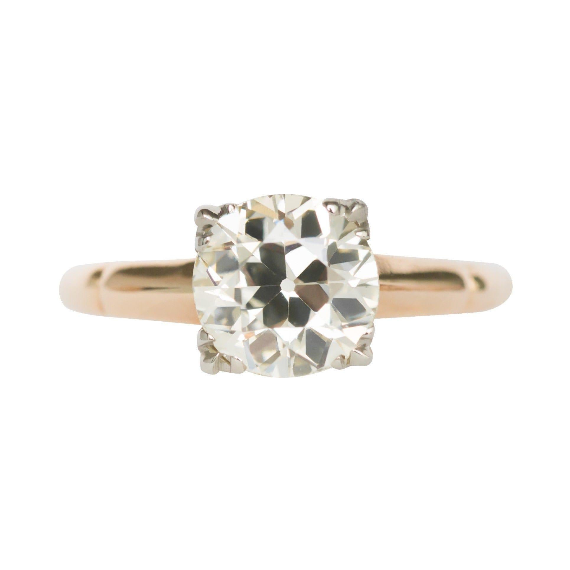 Behold a timeless representation of a diamond solitaire ring from the turn of the century. Gracing this piece is a 1.67-carat Old European cut diamond, renowned for its top-tier clarity, adorned with a nearly flawless VS grade. Its warm body color,