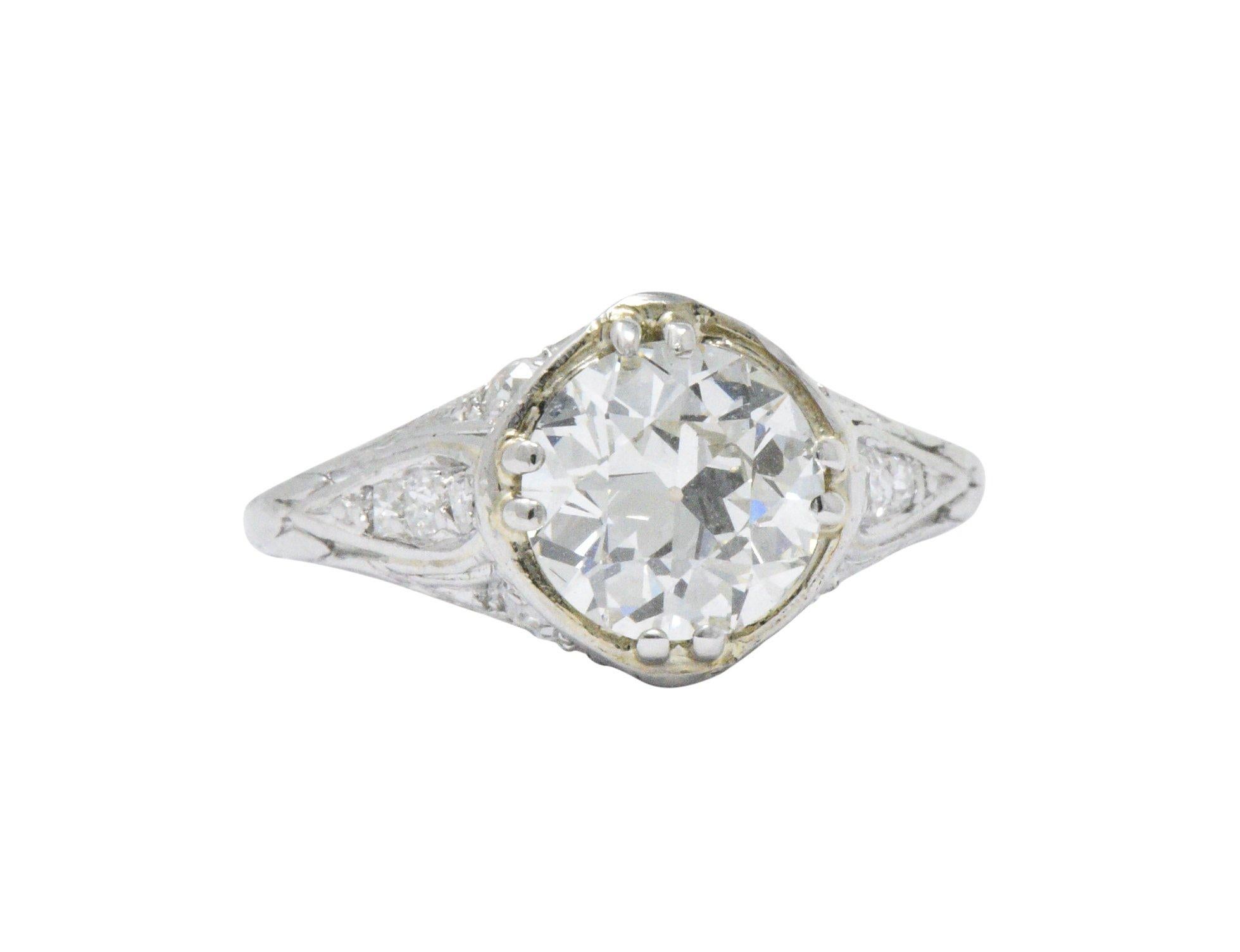 Centering an old European cut diamond weighing 1.54 carats, K color with VS2 clarity

Set low by double prongs in an subtly engraved mounting accented throughout by single cut diamonds weighing approximately 0.22 carat total; eye-clean and