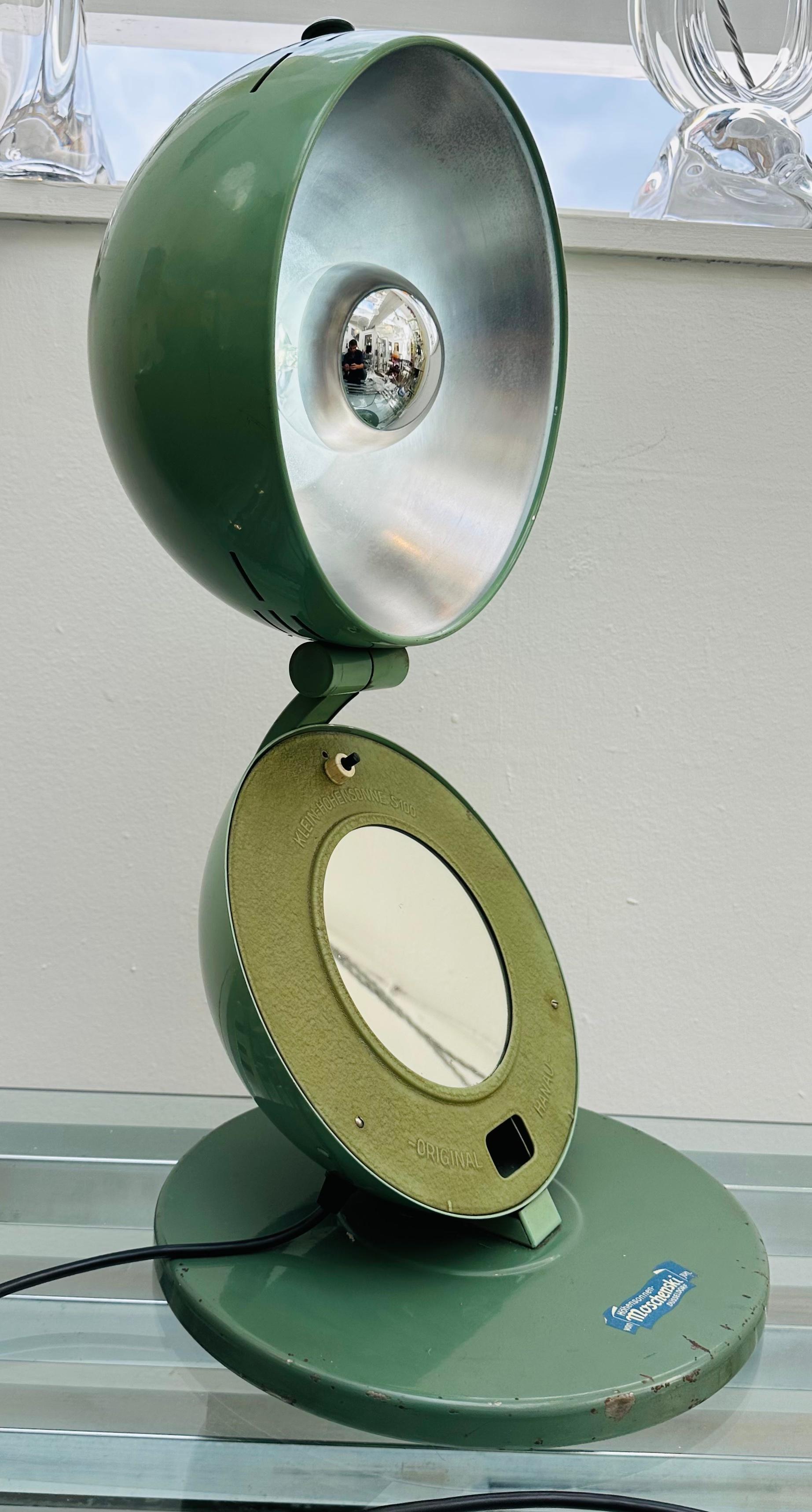 An original circa 1935 German Bauhaus light therapy workshop Industrial lamp in jade-green lacquered steel. The circular base which still retains the original maker's label supports a sphere which opens to reveal a mirror in the lower half part and