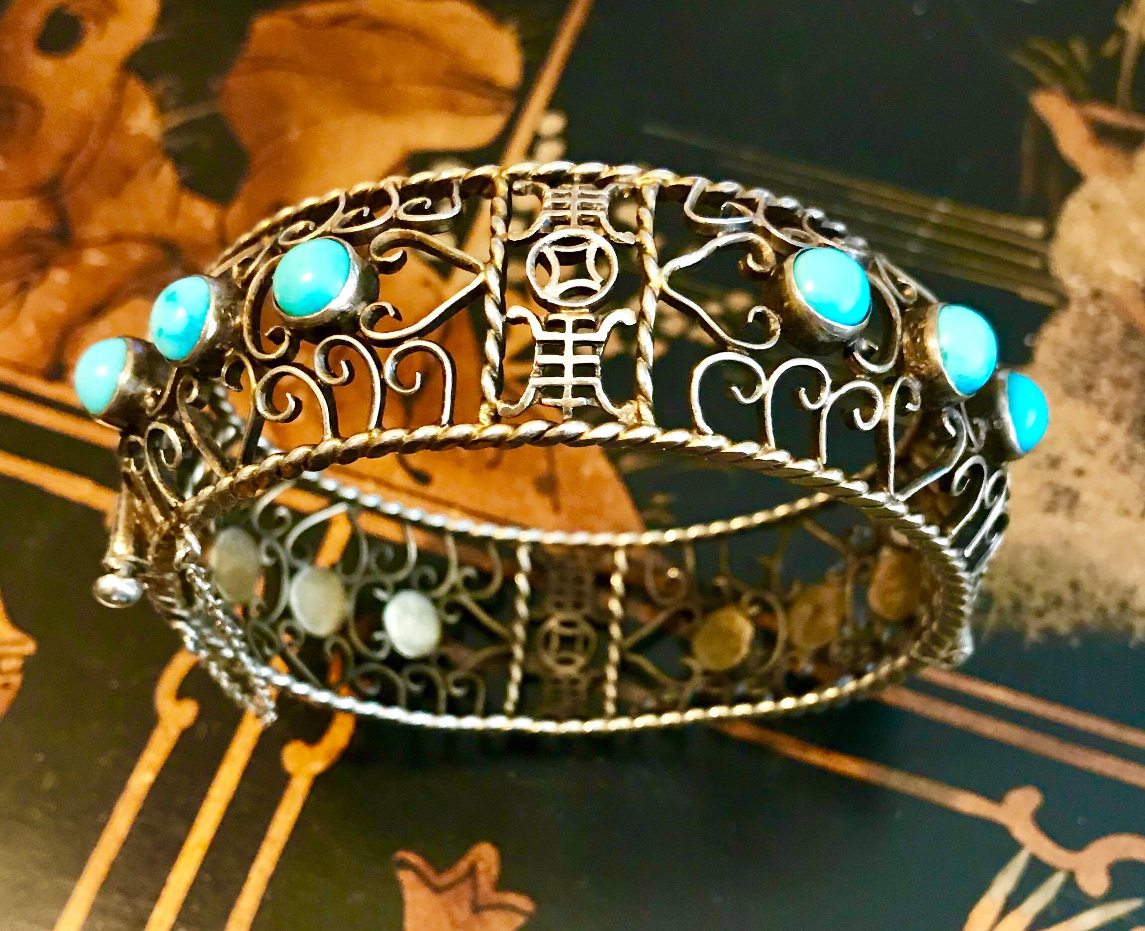 Circa 1930s to 1940s gold plated sterling silver, open work hinged bangle bezel set with 12 round turquoise cabochons.  The bangle closes with a screw clasp and has a safety chain.   The inside circumference is 7.5