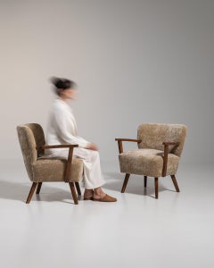 Par de sillones tapizados de estilo moderno de mediados de siglo, de madera de olivo, de alrededor de 1940