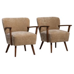 Par de sillones tapizados de estilo moderno de mediados de siglo, de madera de olivo, de alrededor de 1940
