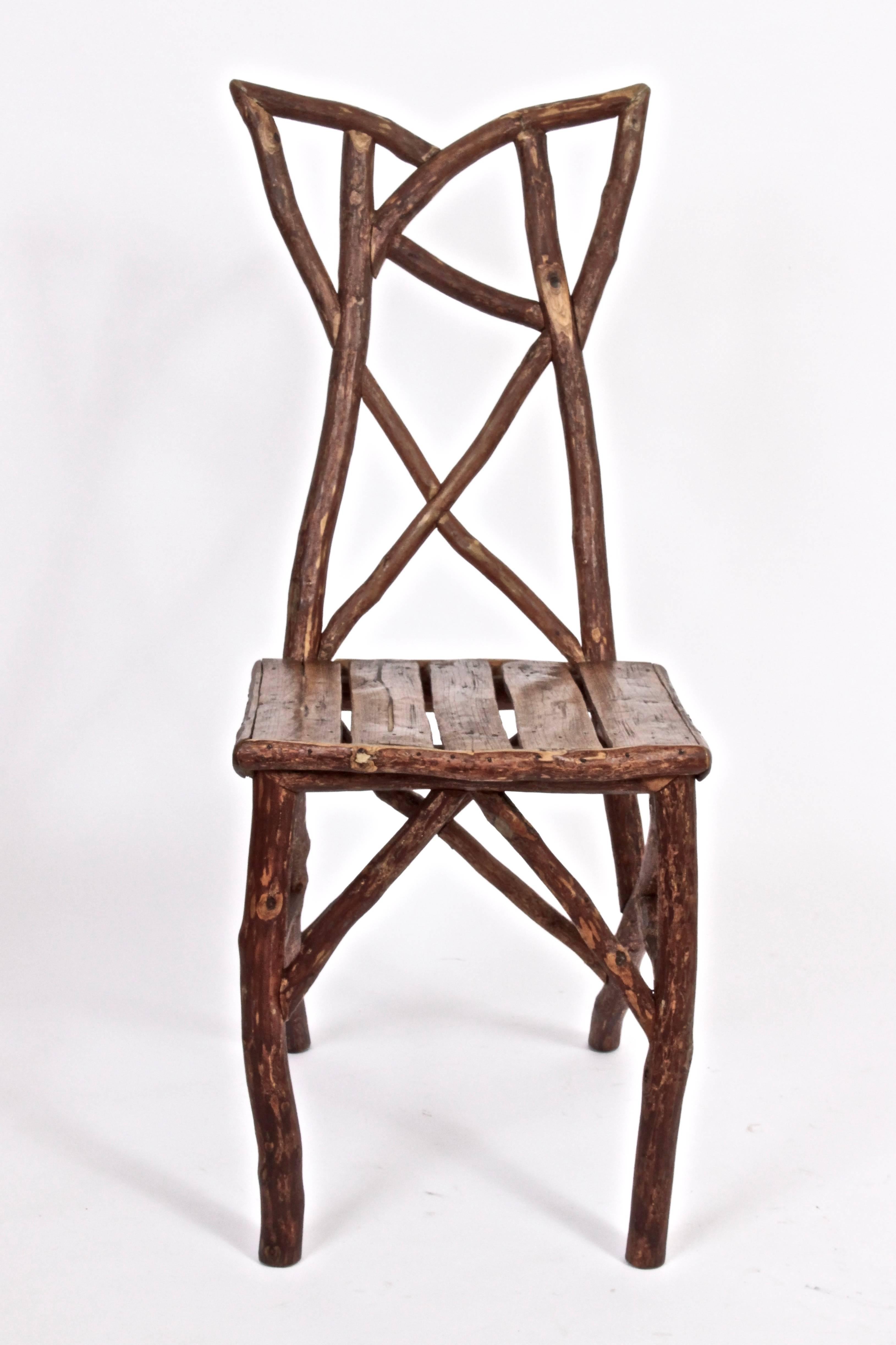 Early 20th Century American hand crafted rustic ranch Side Chair. Featuring a comfortable slatted seat and branch border.  Sculptural. Art. Foyer. Hallway. Additional seating
 