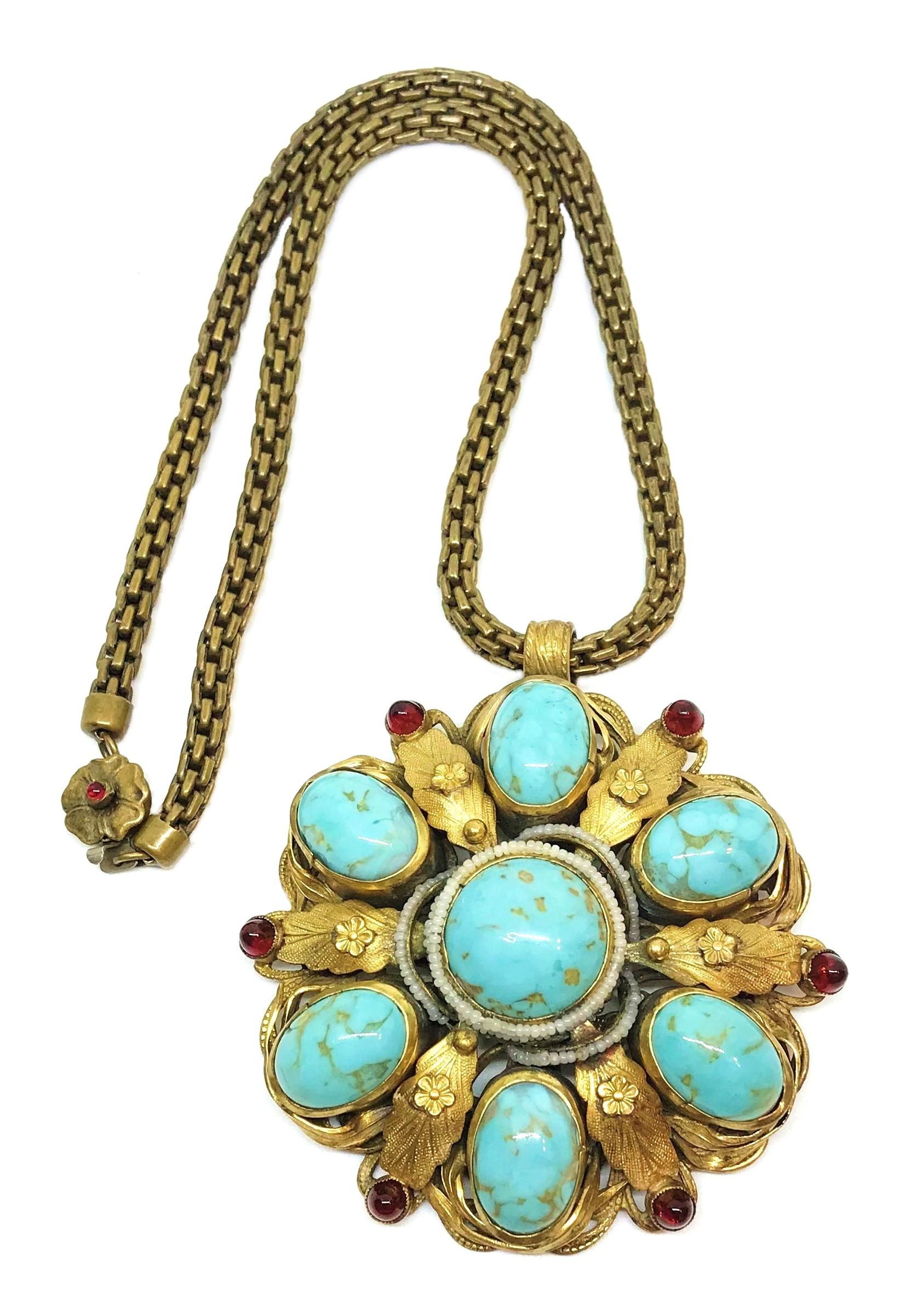 Circa 1940s gold tone metal chain necklace with a large, ornate pendant bezel set with oval and round turquoise glass cabochons.  The pendant measures 3.25