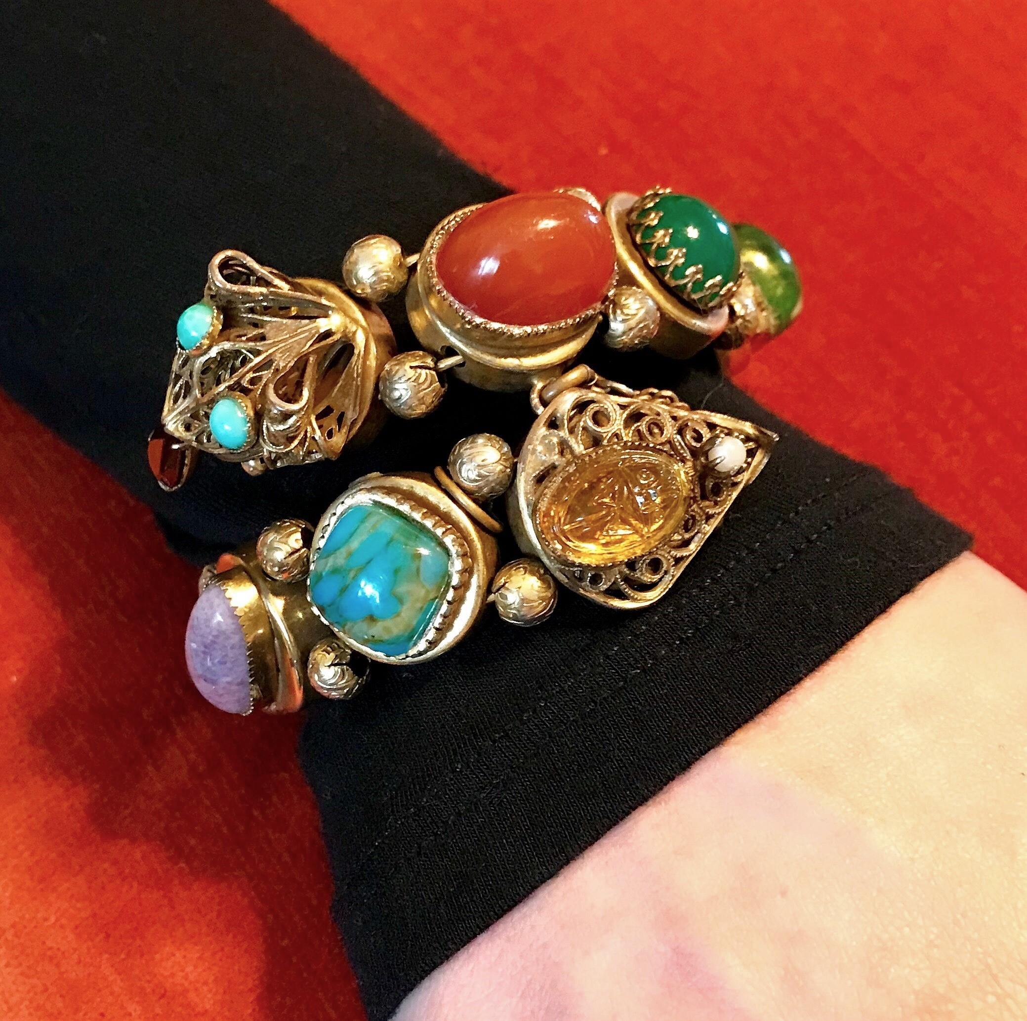 Circa 1940s gold tone metal wrap bracelet bezel set with large glass cabochons in carnelian, jade, turquoise and amethyst colors with a topaz glass molded scarab stone on one end and a filigree snake head on the other end set with faux-turquoise