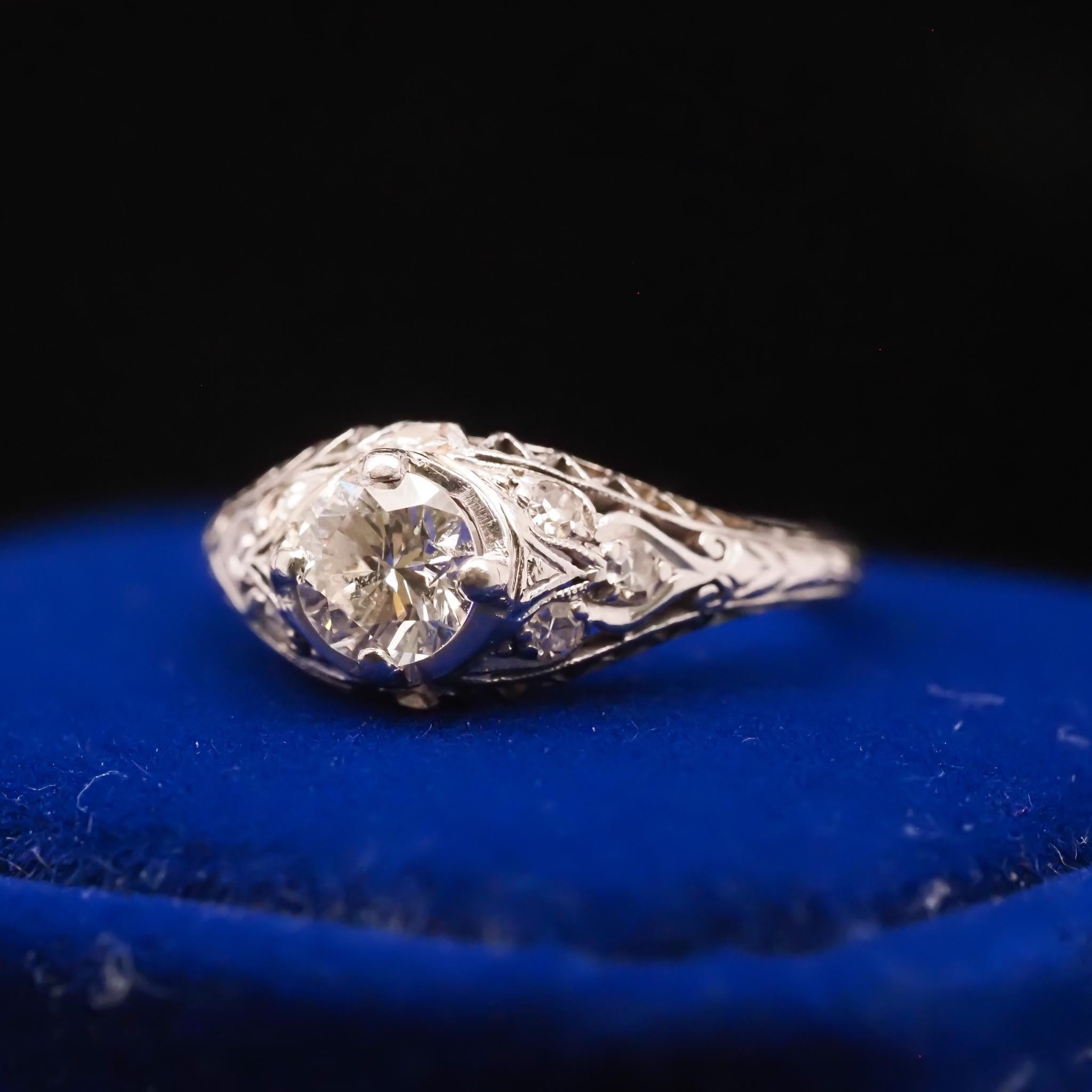Year: 1940s
Item Details:
Ring Size: 5.75 (Sizable)
Metal Type: Platinum [Hallmarked, and Tested]
Weight: 3.9 grams
Diamond Details: .60ct, Transitional Round, G color, SI1 Clarity
Side Stone Details: .10ct total weight, G Color, VS Clarity,