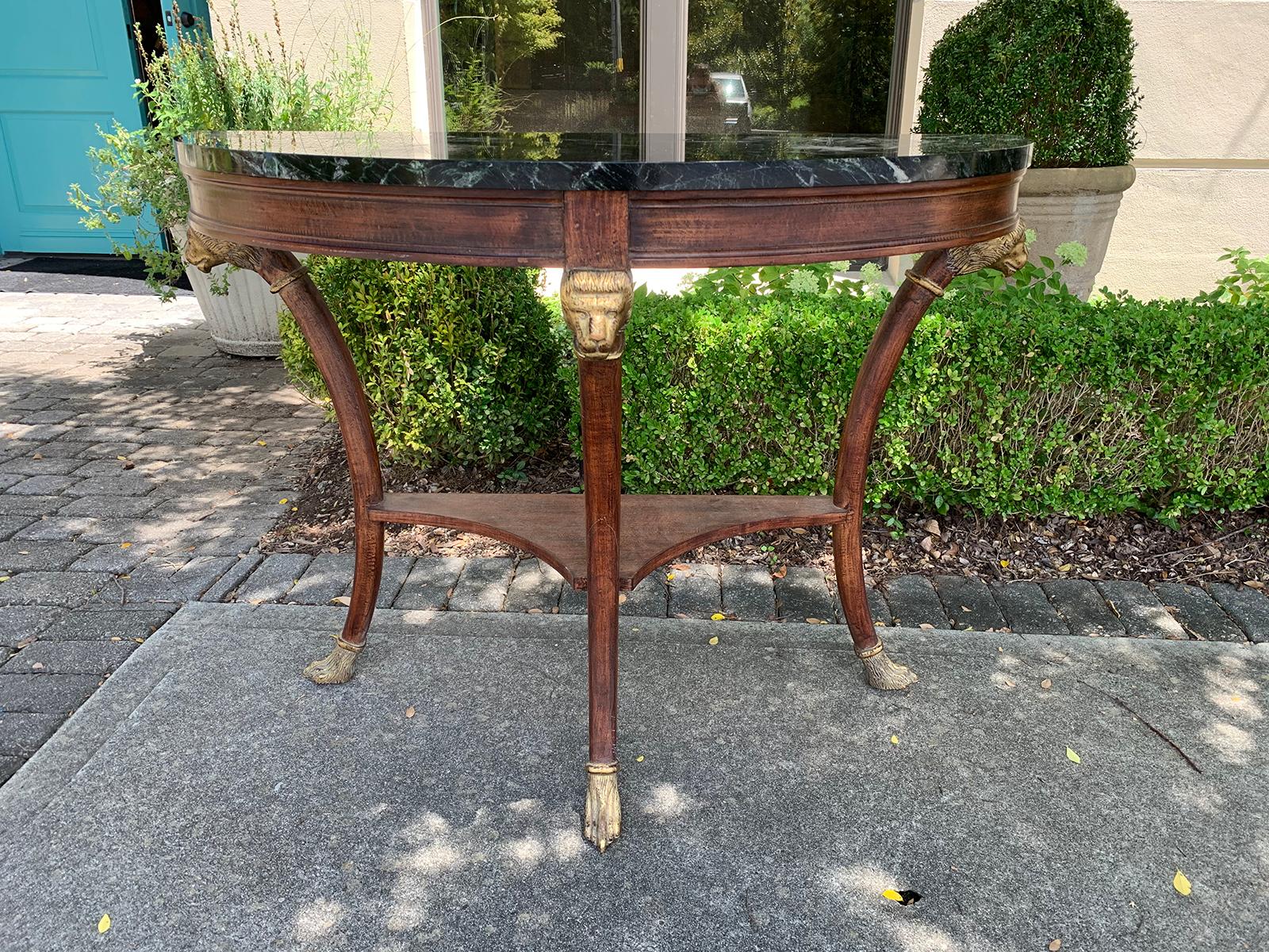 20th century circa 1950s Italian neoclassical marble-top faux bois demilune console table with carved and gilded lion heads and paw feet, old label.
Marble is 1