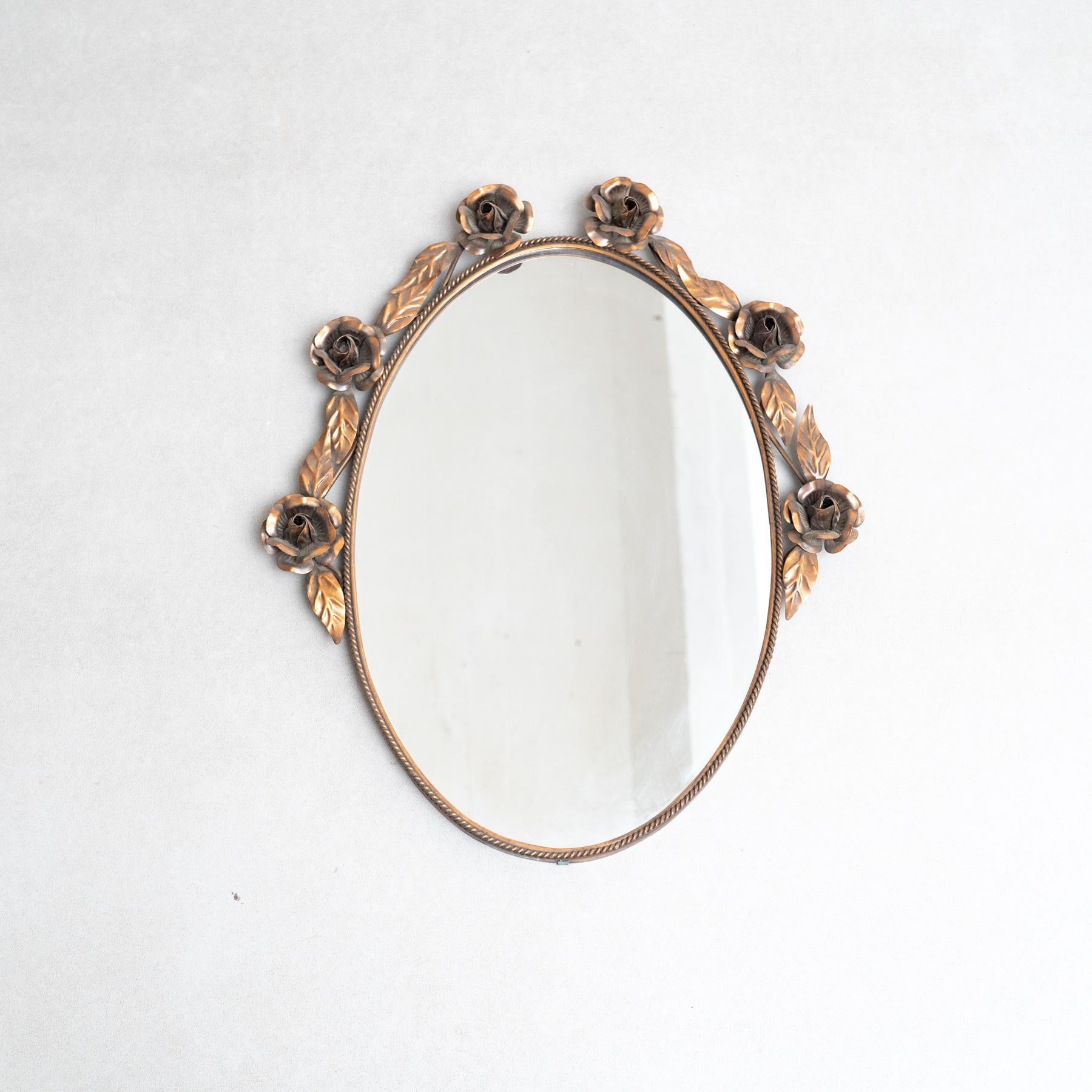 Espejo de metal, hacia 1950.  Fabricado tradicionalmente en España. Por diseñador desconocido.  Abrace el encanto del diseño de mediados de siglo con este espejo circular de metal y madera, fabricado tradicionalmente en España por un diseñador