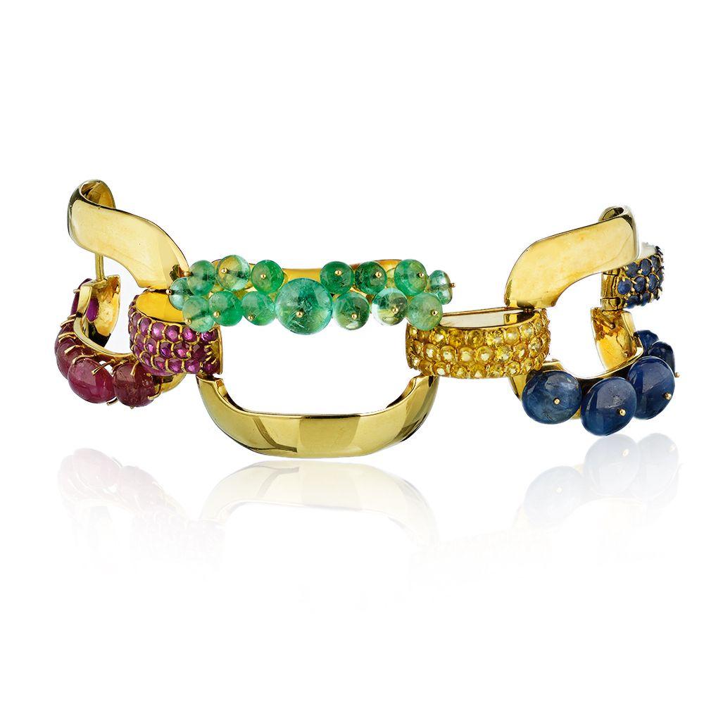 Ein dreigliedriges Armband aus Rubin, Smaragd und Lapis, mit Saphiren als Pave-Verschluss, alle in 18K Gelbgold gefasst.  Um 1950er.
Ungefähr 1,25 Zoll breit. 8 Zoll lang. 
