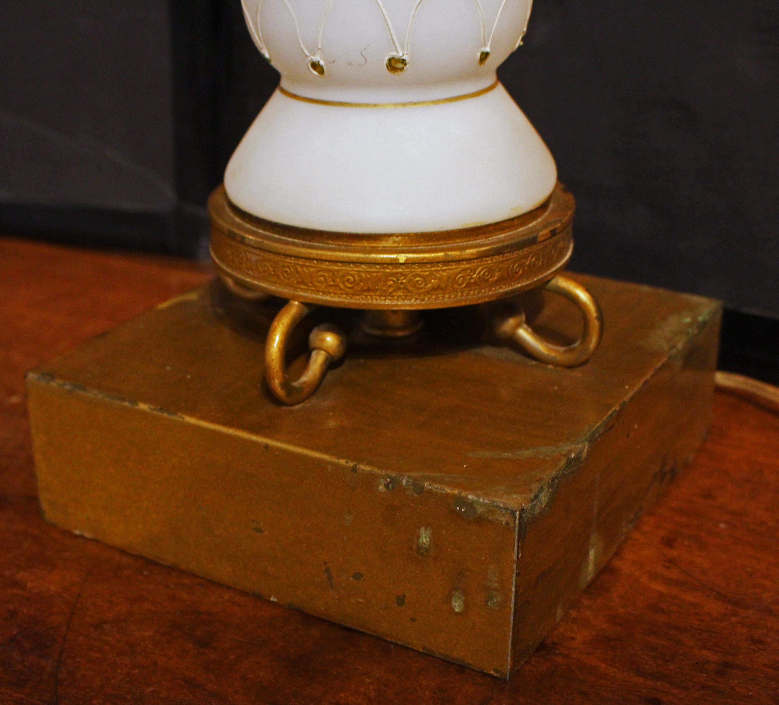 A pair of glass faux marble lamps, circa 1950s, American. Decorated with fish net glass applique. Hollywood Regency Era. Vase forms on gilt metal bases with scrolled legs on integral plinth square bases. Some wear to the gilt metal. Condition